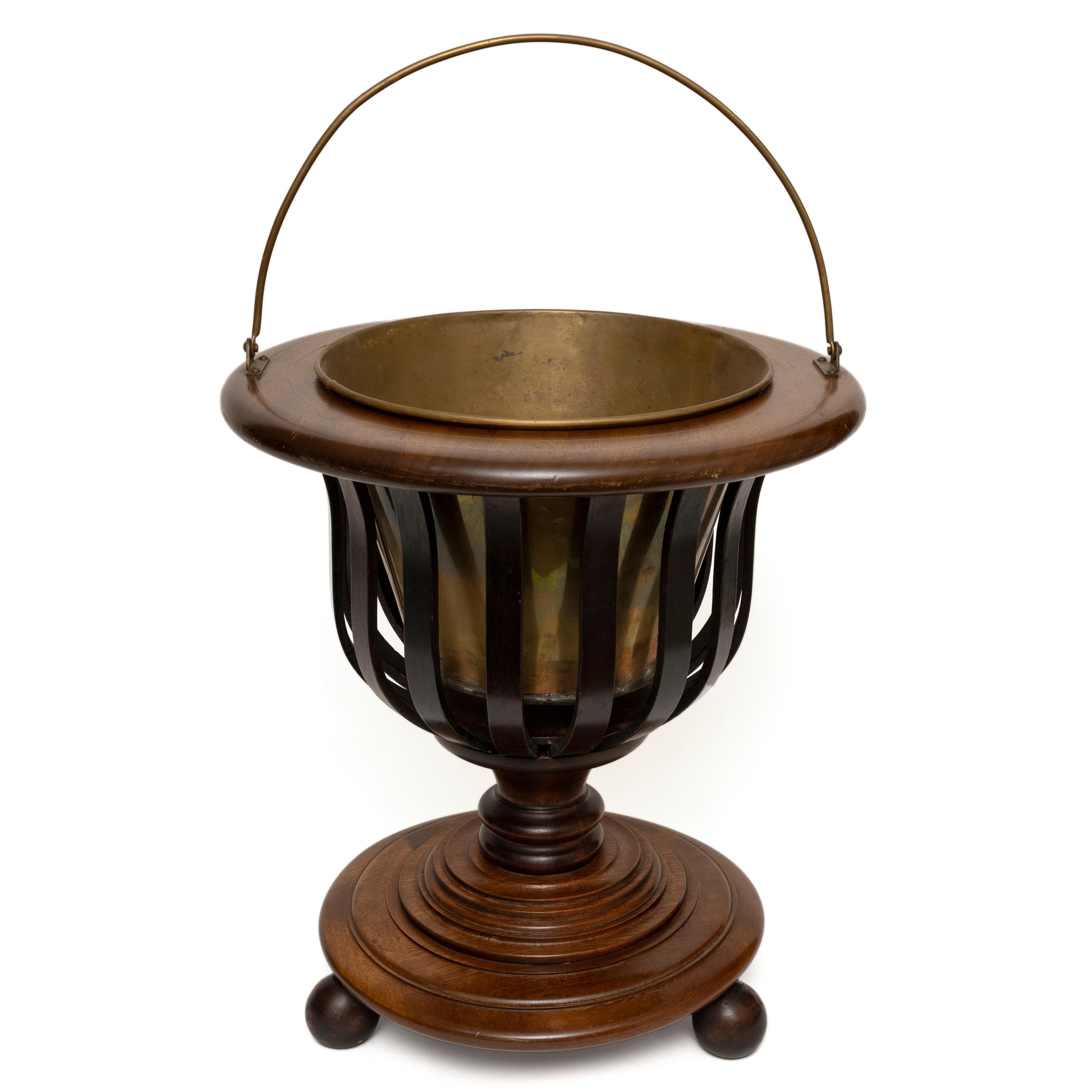 Elegant Urn Shaped Georgian Revival Wine Cooler or Jardiniere with Original Brass Bucket
Elegant vase shape with curved slats allowing the brass of the bucket to be seen and also reflect light
The removable original brass bucket most likely intended