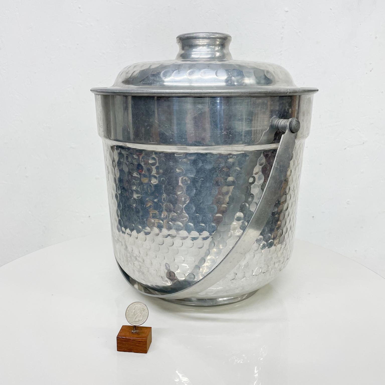 Ice bucket
Rare size XL ice bucket made in Italy. Hand forged hammered aluminum. 
Measures 18 H handle with handle 12.75 height w/o handle x 11 diameter x 12.5 wide
Stamped underneath Italy
Original preowned unrestored condition. Wear present.