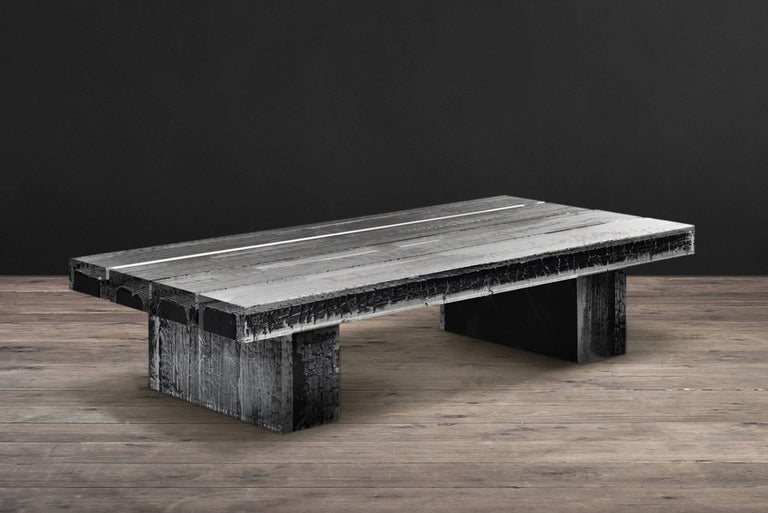 Coffee table ice burnt with burnt timber in crystalline
acrylic. Ice-cold smooth appearance contrasts with
charred rugged timber. Coffee table features four
beams of timber encased in acrylic, set atop two large
timbers also in acrylic. The