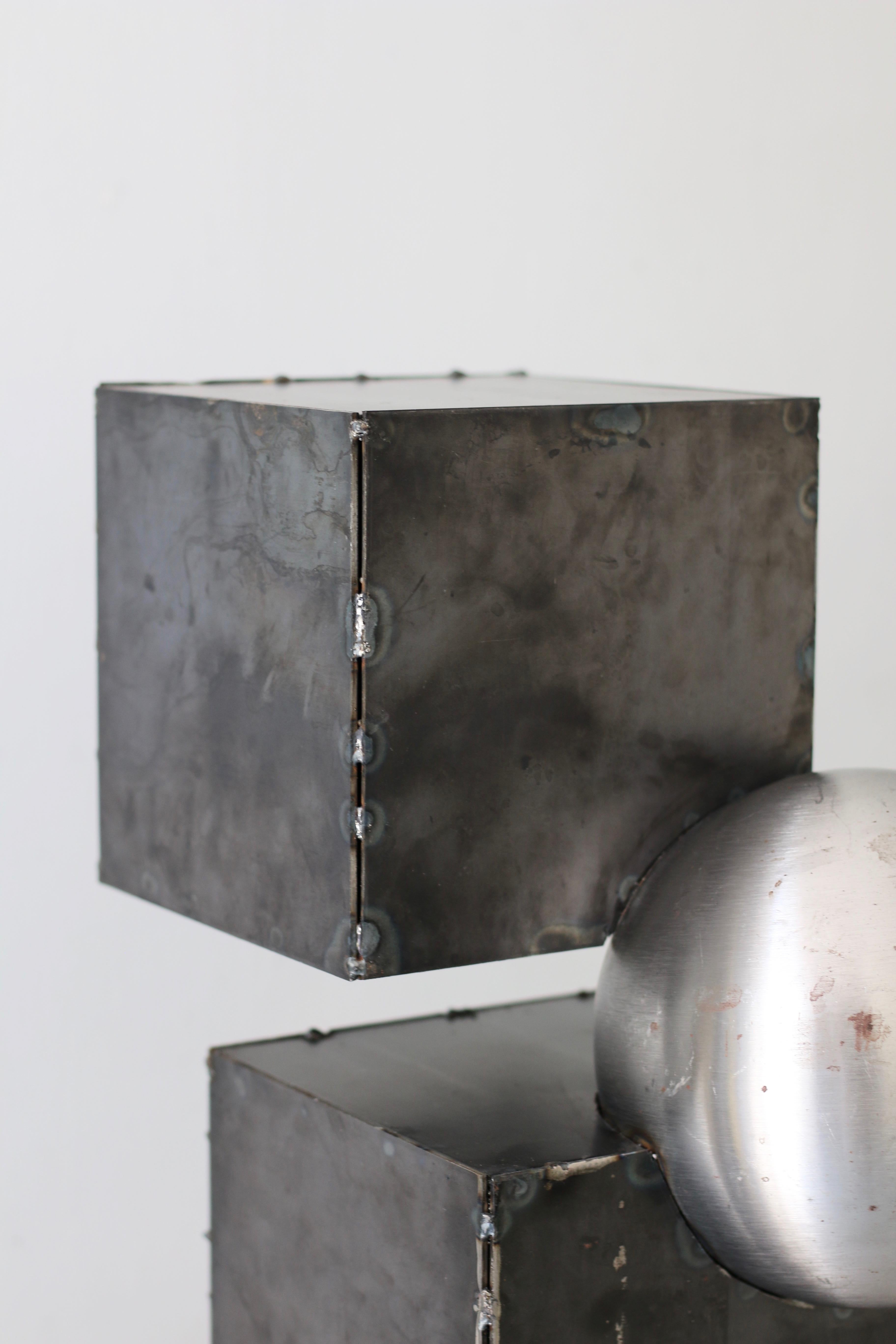 'Ice Cube' sculptural side table in welded raw steel. It features clean geometry and Brutalist influenced design. Heavy weight and extremely durable. Handcrafted, unique and signed.

Sabine Mezkaze Berzina (b.1988) is multi-media artist, furniture