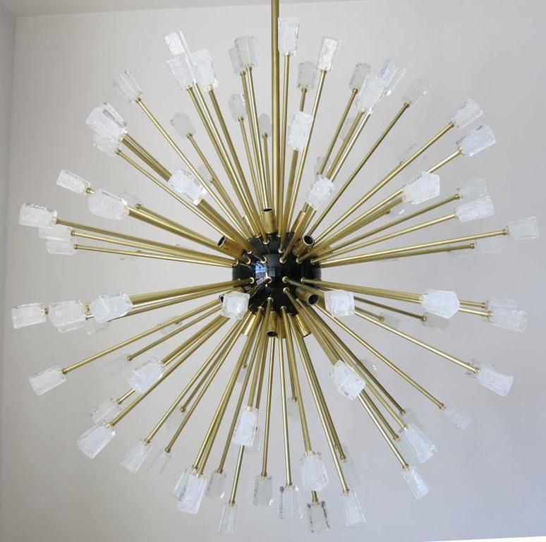 Lampadario sputnik moderno italiano composto da 96 cubi unici in vetro di Murano trasparente soffiati con la tecnica Pulegoso per fornire un aspetto opaco con bolle a grappolo all'interno del vetro, montati su una struttura in metallo di ottone con