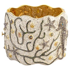 Bracciale con diamanti di ghiaccio e disegno di vita marina in oro e argento 18 carati