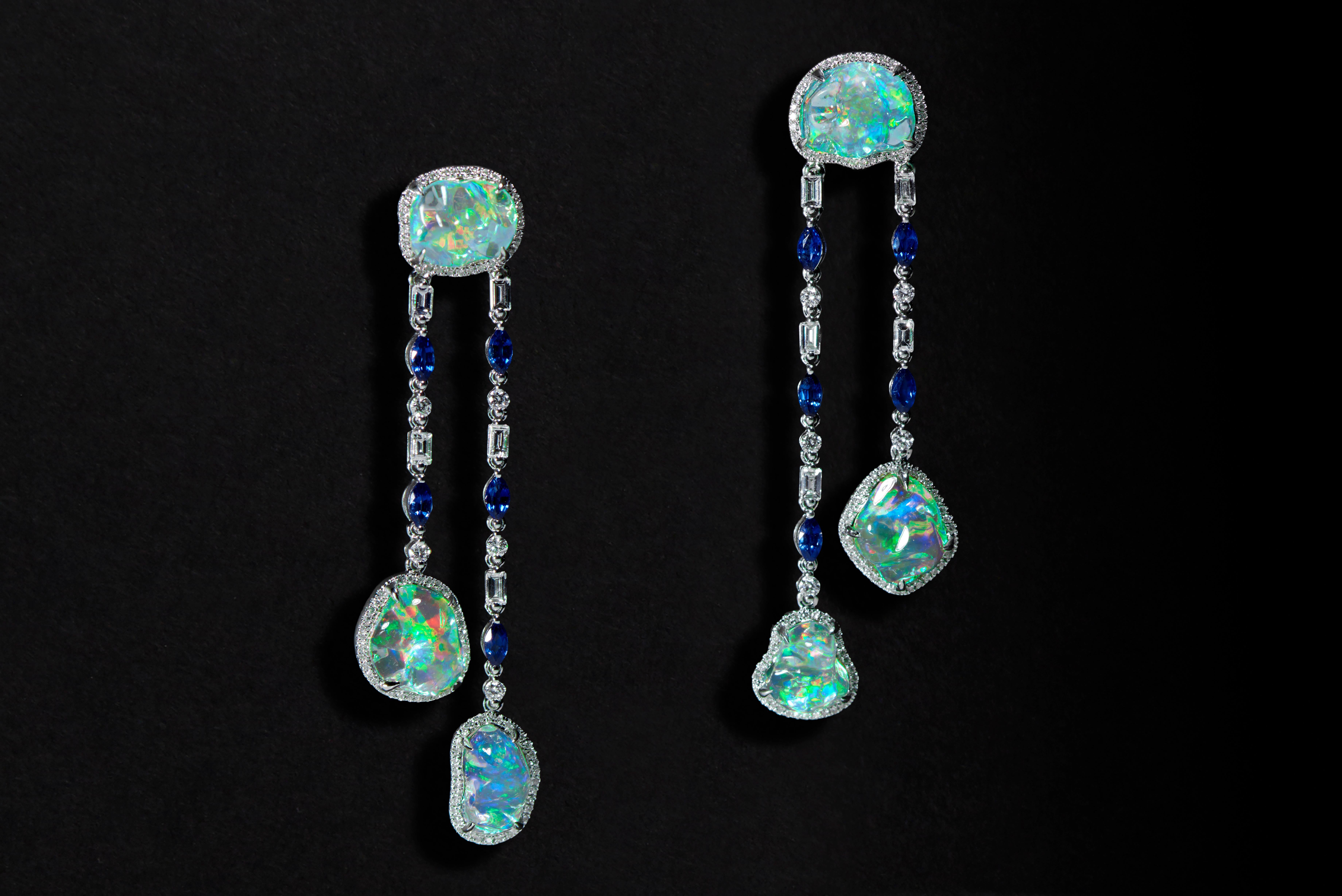 Bursting with saturated colors, the ethereal Ice drops Clear Fire Opal Blue Sapphire and Diamond Earrings highlight the natural beauty of gemstones and showcase an innate sense of contemporary fashion thinking. Dangling from a sinuous round top, two