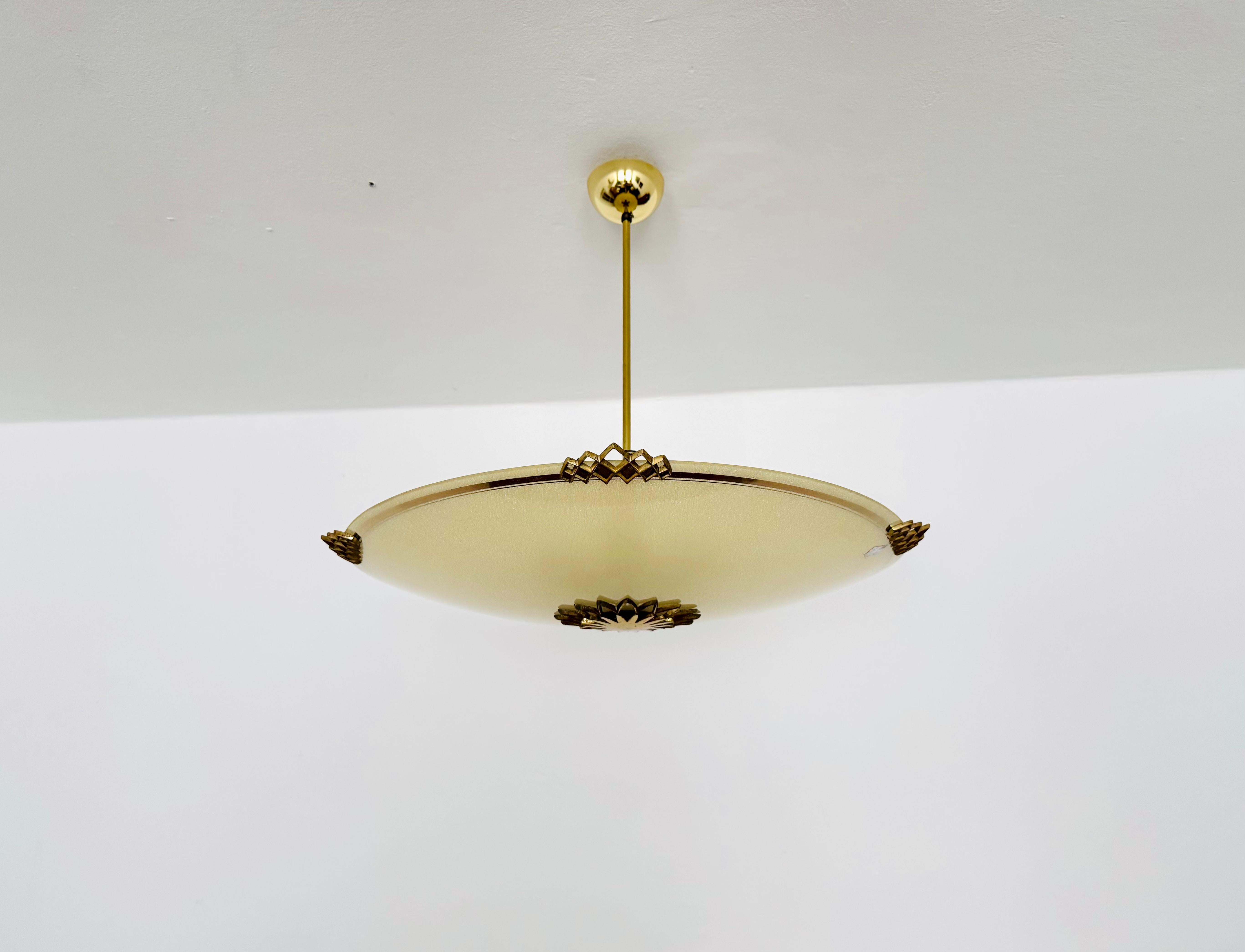 Lampada da soffitto eccezionalmente bella e grande degli anni '1950.
Un design molto fine e bello che si adatta meravigliosamente a ogni stanza.
Il vetro ha un motivo molto bello e degli elementi metallici molto decorativi.
Si crea una luce molto