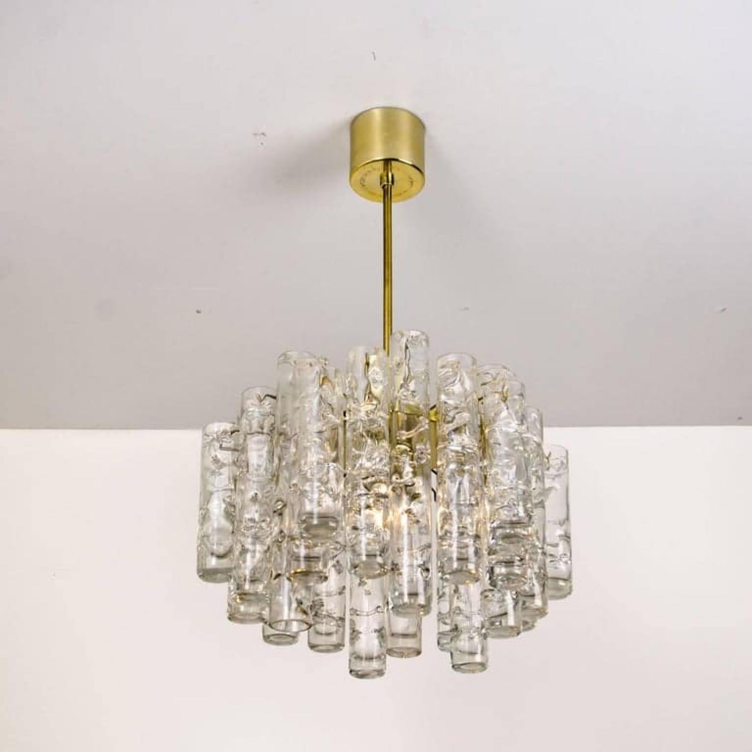 Magnifique lustre en verre soufflé à la main de la manufacture Doria, avec 24 grands tubes en verre glacé de trois longueurs différentes, un cadre plaqué laiton avec une ampoule E 27, design haut de gamme des années 1960. Les tubes en verre glacé