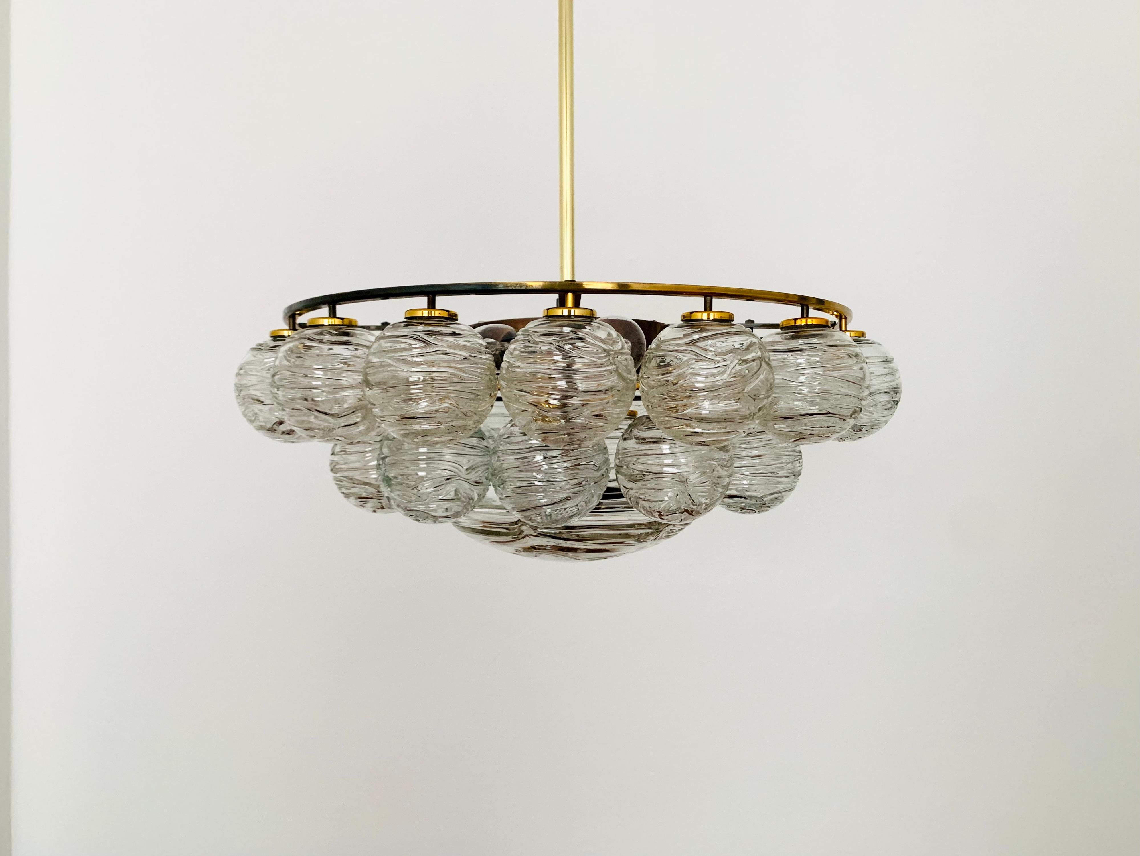 Fabulous ice glass chandelier from the 1960s.
The lamp with the 28 glass pendants is very elegant and impresses with its wonderful design.
The structure in the glasses creates a spectacularly sparkling light.
An absolute