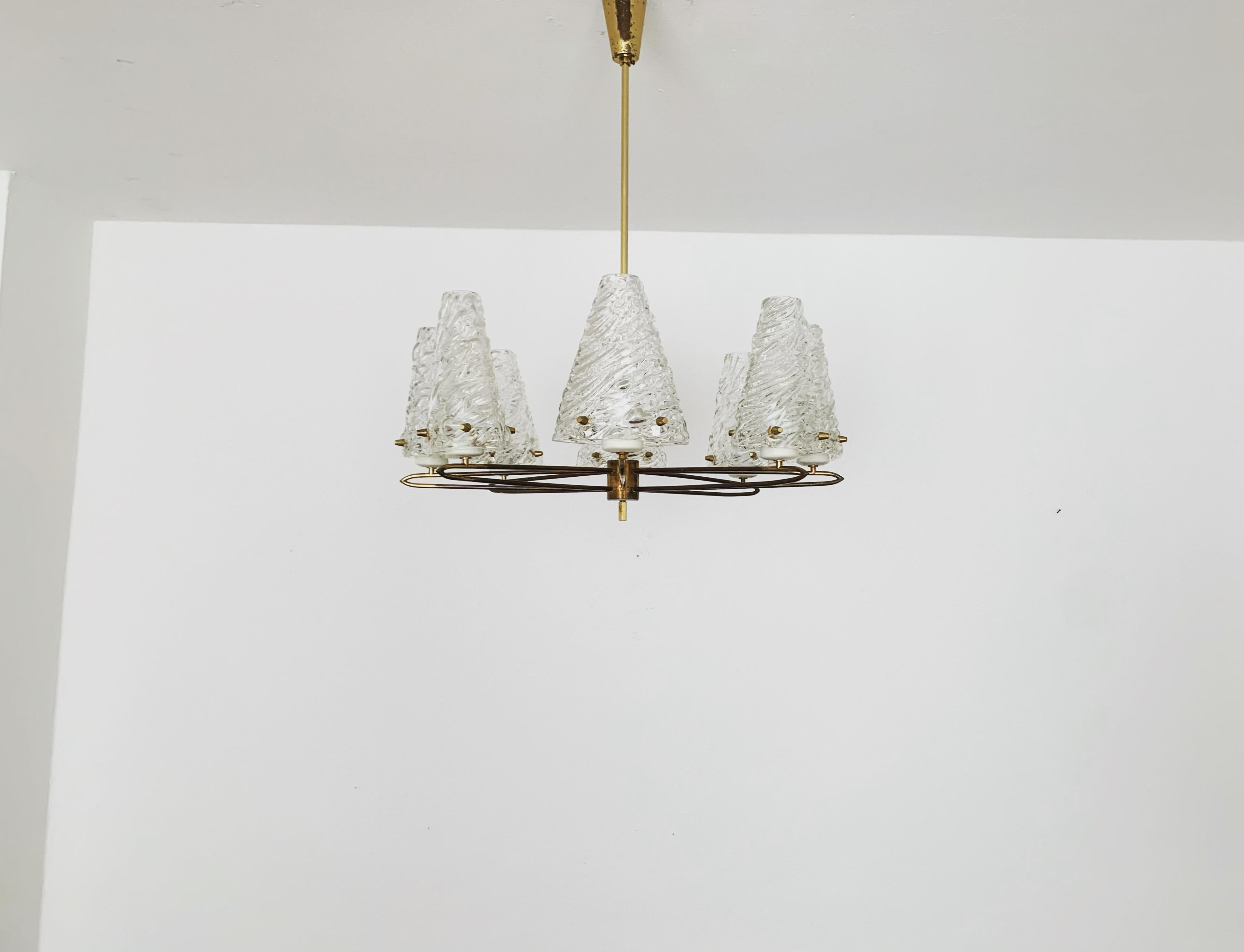 Stunningly beautiful crystal glass chandelier from the 1950s.
Wonderful mouth-blown glass with a great structure.
The filigree brass frame underlines the noble appearance.
The design and the materials used create a great glittering light.
An