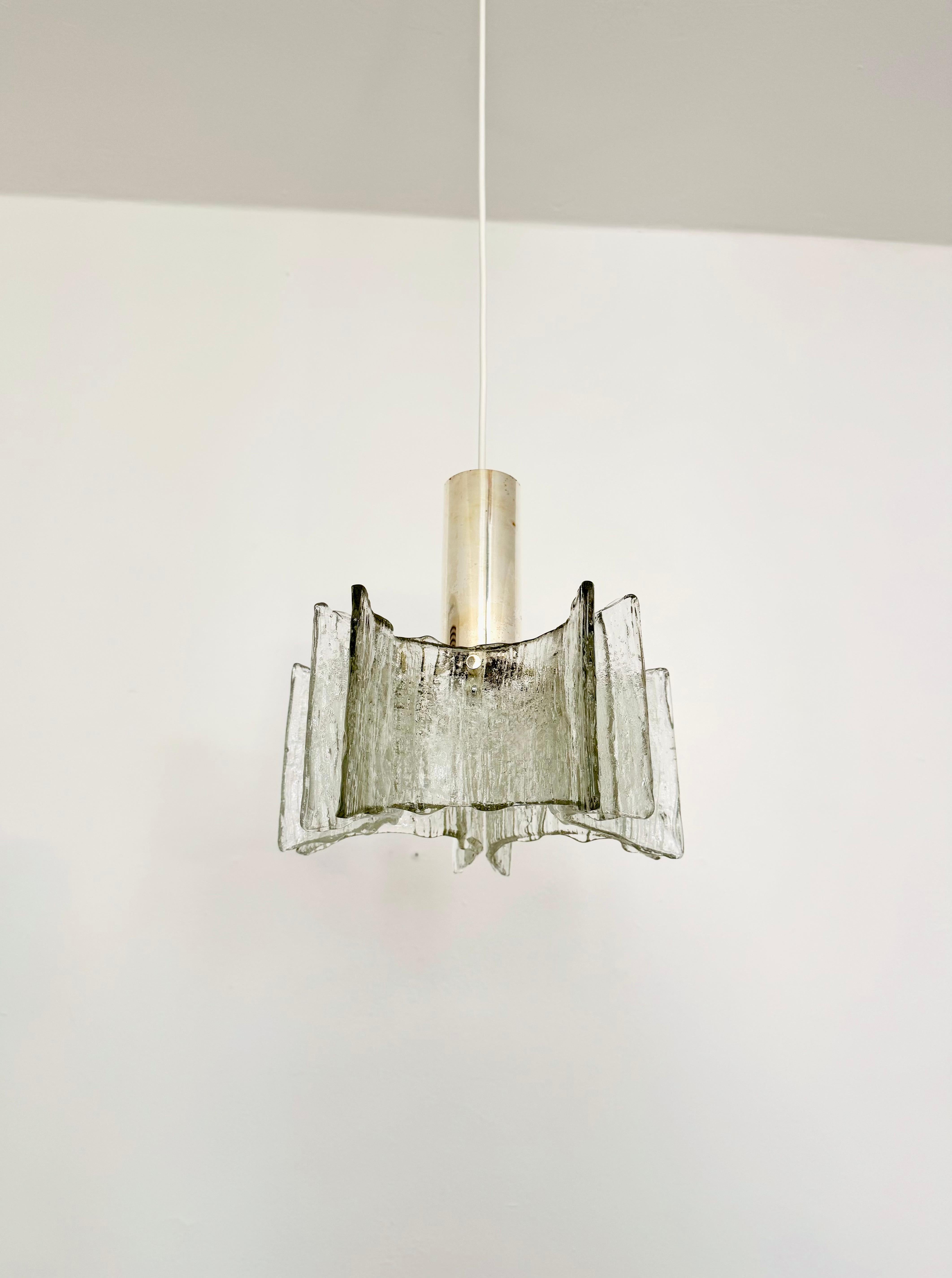 Lampada a sospensione in vetro ghiaccio molto bella e di alta qualità degli anni '60.
La lampada con i 5 pendenti di cristallo è molto elegante.
La struttura dei bicchieri crea una luce molto frizzante.

Produttore: Kaiser Leuchten/Kaiser