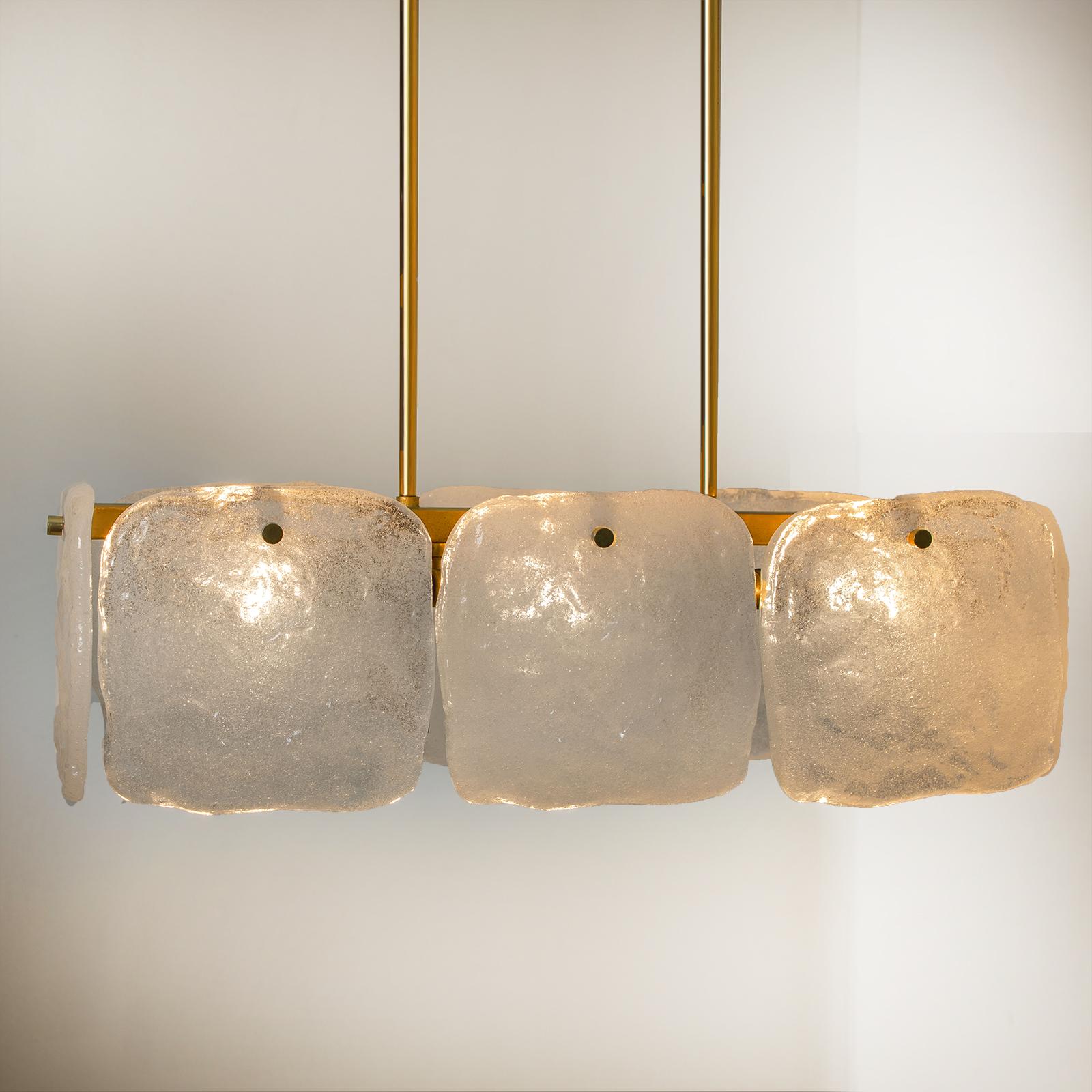 An ice glass pendant lights designed by J.T Kalmar, manufactured by Kalmar Franken, Austria in the 1960s.
High-end and handmade design from the 20th century. The pendant/chandelier has eight large squares of white, opaque textured glass shades
