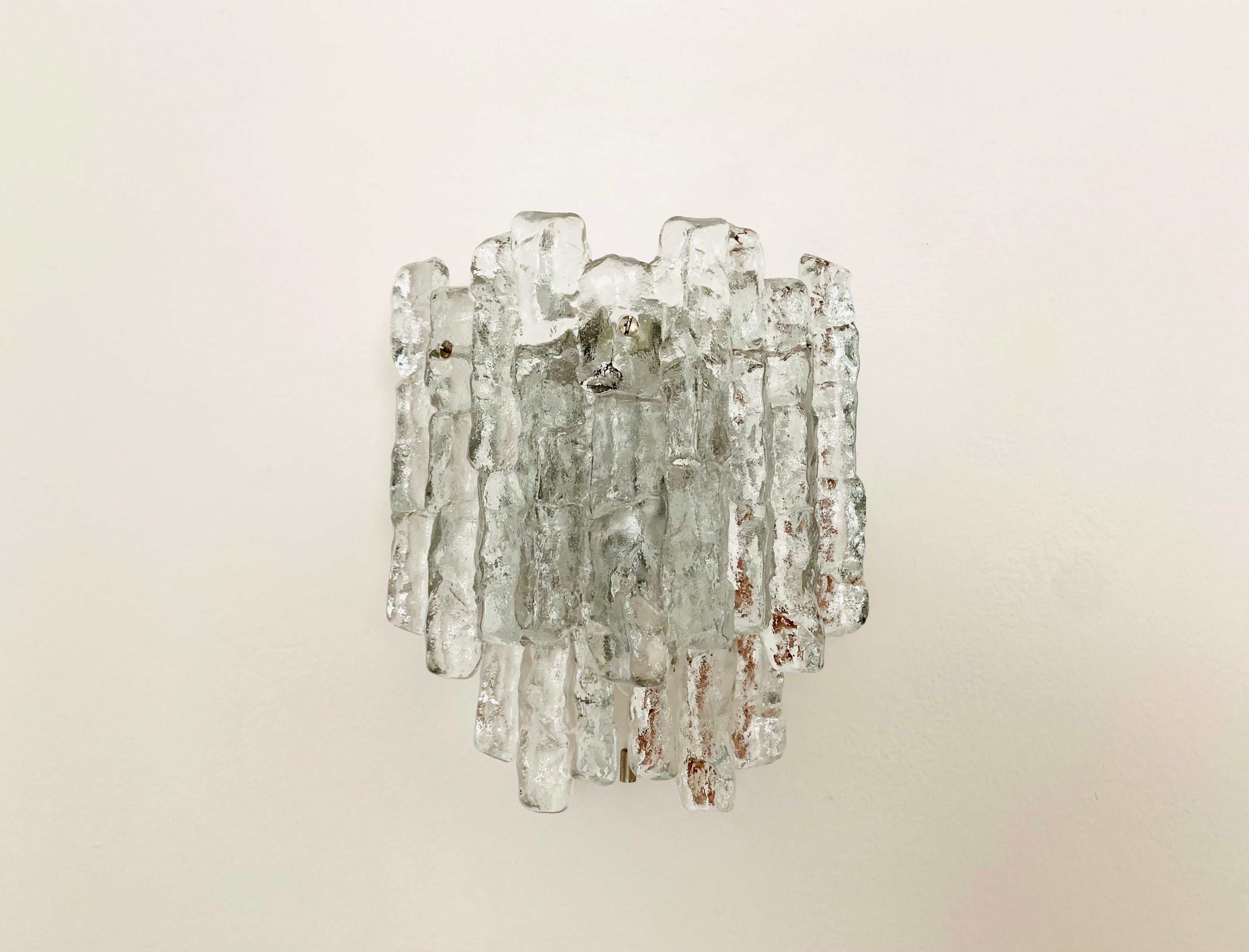 Very nice ice glass wall lamp from the 1960s.
Very pleasant lighting effect thanks to the ice glass, which spreads an elegant, sparkling play of light in the room.
Great design and high-quality workmanship.

Manufacturer: Franken KG
Design: J.T.