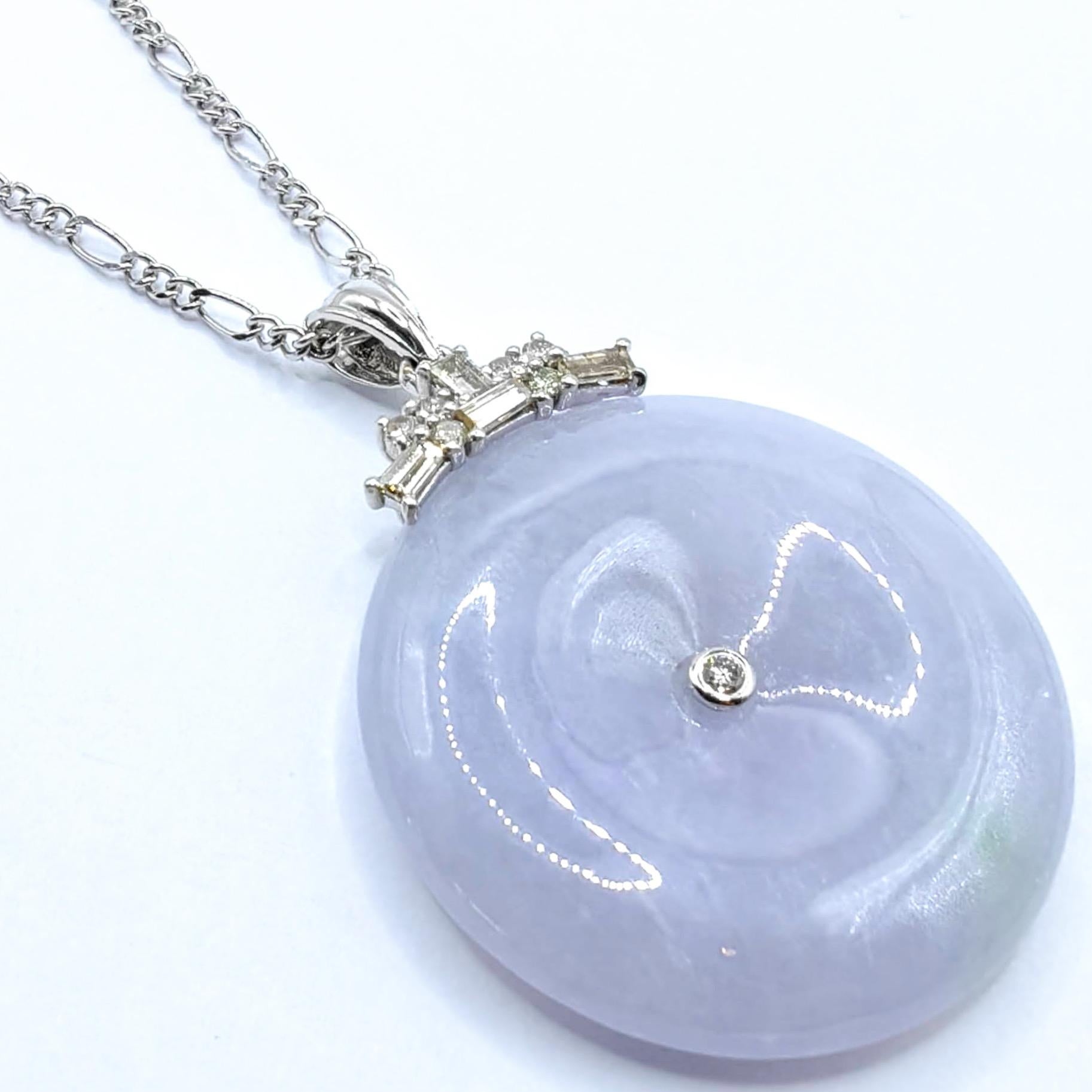 Questo splendido ciondolo presenta un disco perfettamente rotondo di giadeite color lavanda ghiaccio, che mette in mostra l'eccezionale traslucenza e la bellezza eterea della pietra. La giada presenta una delicata tonalità lavanda con sottili