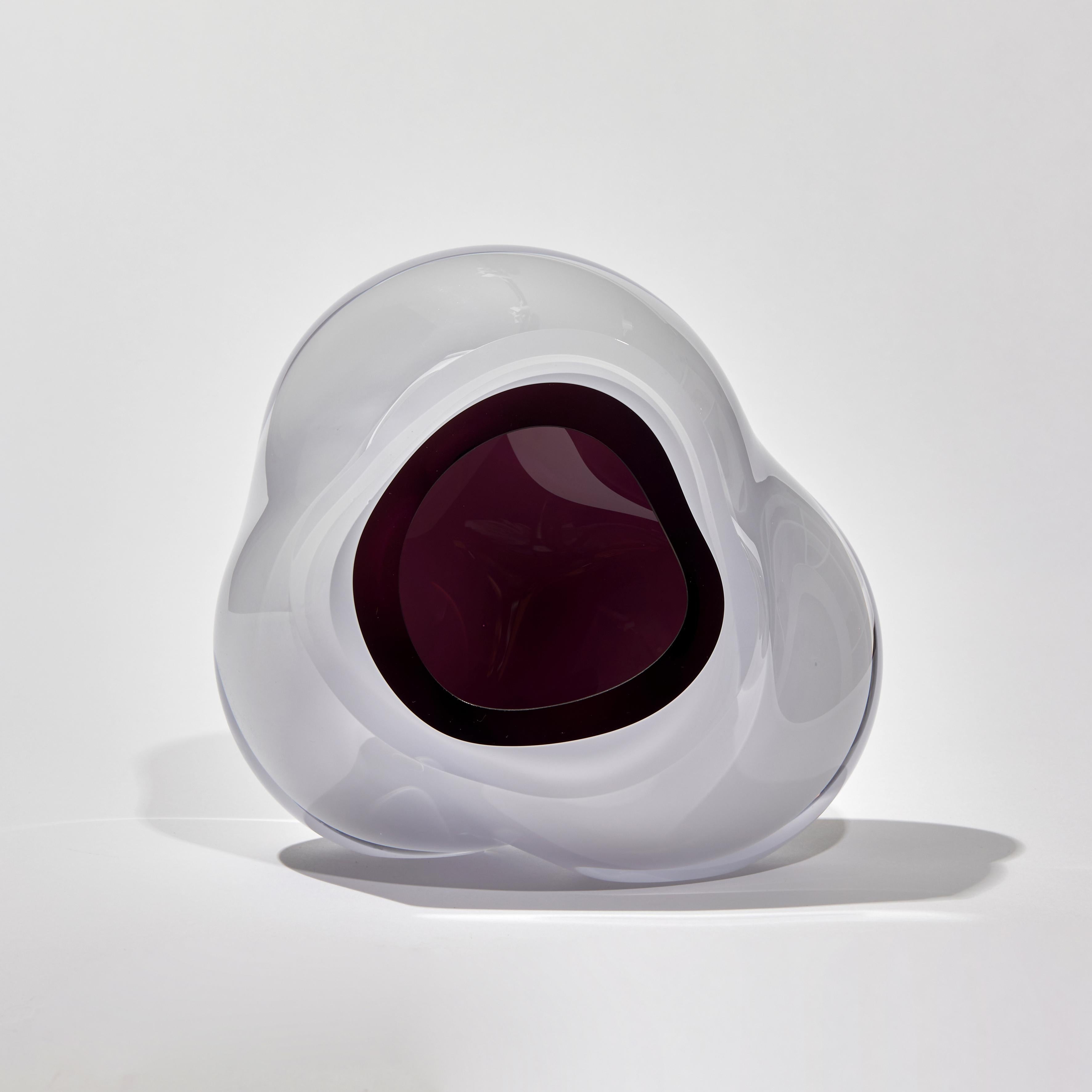 Ice Vug in Aubergine ist eine einzigartige mundgeblasene Skulptur der britischen Künstlerin Samantha Donaldson. Eine bezaubernde, ätherische Skulptur mit einem gletscherweißen Äußeren und einem reichhaltigen aubergine/violetten, höhlenartigen