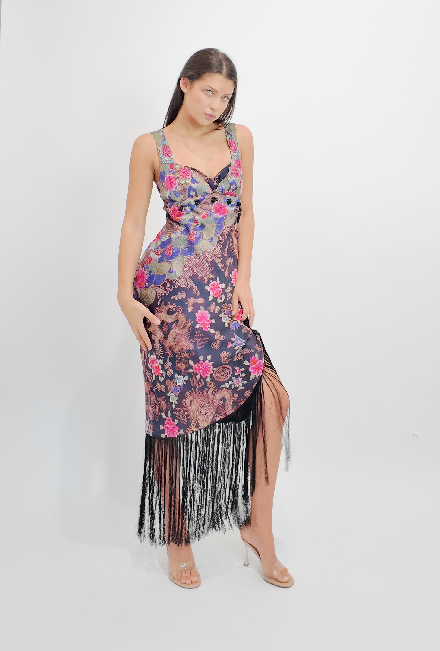 Questo abito vintage di Iceberg combina un'elegante seta con una silhouette ispirata al kimono, caratterizzata da delicate stampe floreali e intricati ricami. Le sue frange giocose aggiungono movimento, rendendolo ideale per ballare o per una serata
