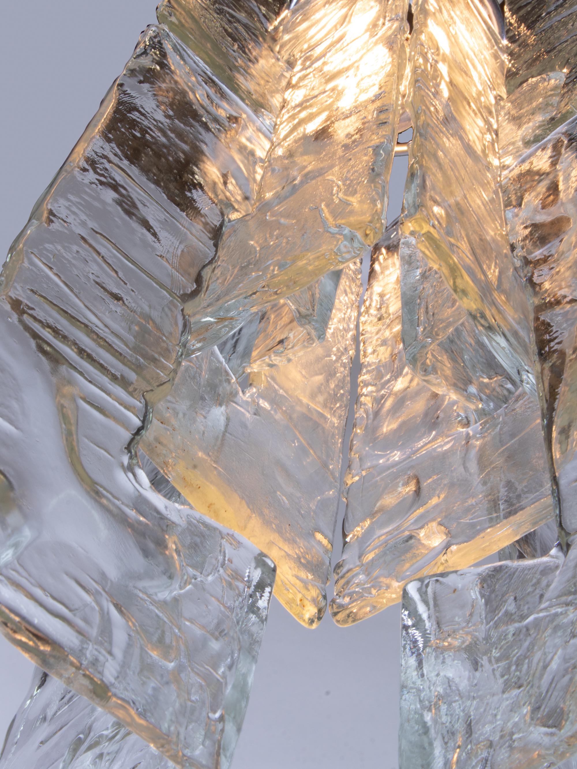 Elegante lampe suspendue avec de grands éléments en verre de Murano, clairs et lourds, imbriqués les uns dans les autres, sur une monture chromée. Le verre suspendu ressemble à de la glace. Conçu par Carlo Nason. Gemme de l'époque. Avec ce