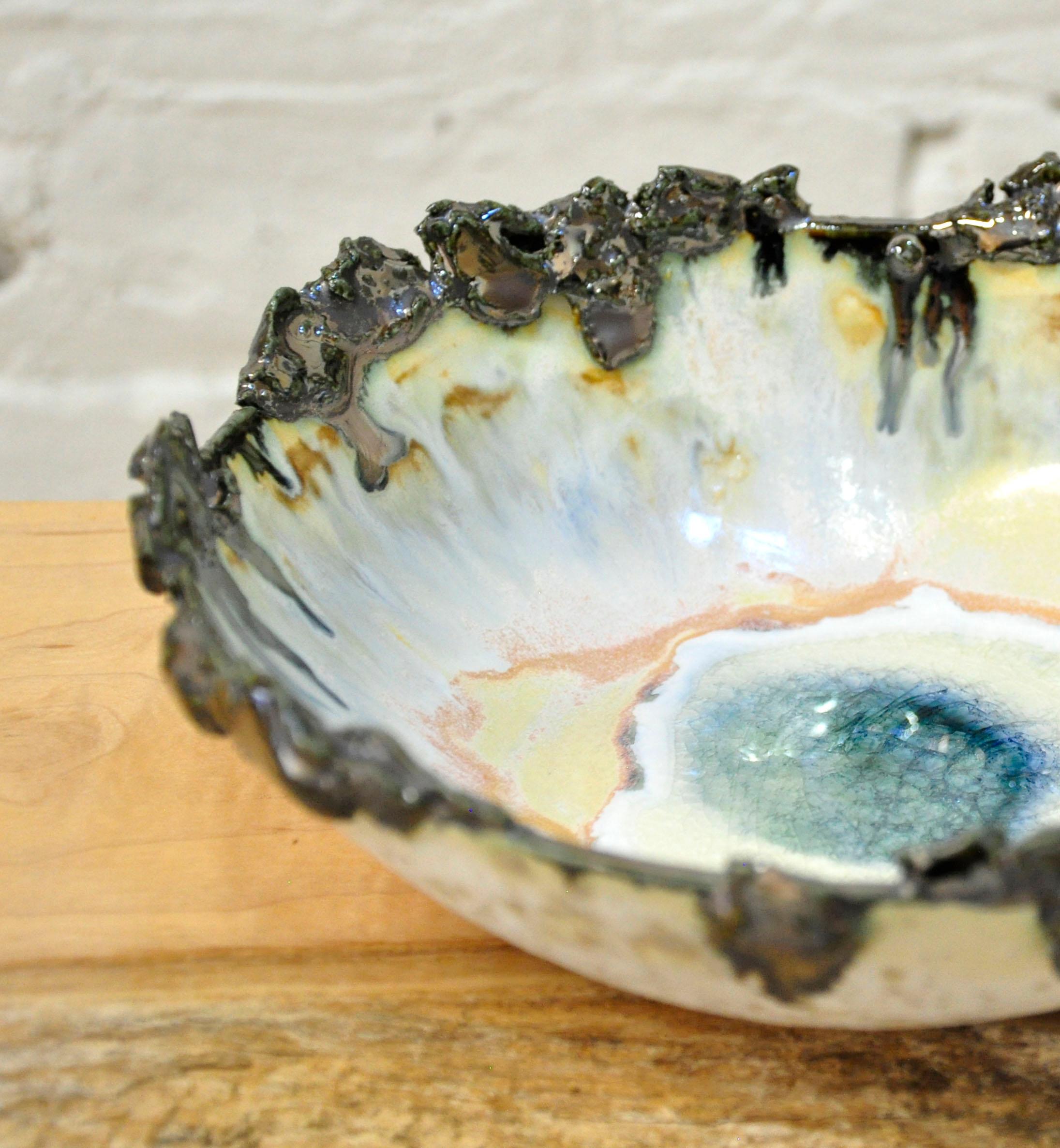 This Iceland bowl by Minh Singer is hand-built in white stoneware and finished with metallic glaze and glass. Singer's mesmerizing technique requires several firings.

Each piece is lovingly handmade and unique by nature. 

This bowl is a show