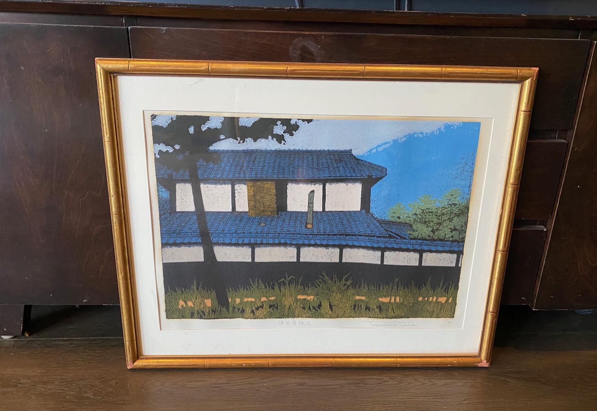 Une magnifique gravure sur bois de l'artiste japonais Ichiro Fukushima, magnifiquement composée et colorée dans les tons de terre.  Cette œuvre représente l'extérieur d'un temple ou d'une maison de campagne japonaise traditionnelle, ainsi que le