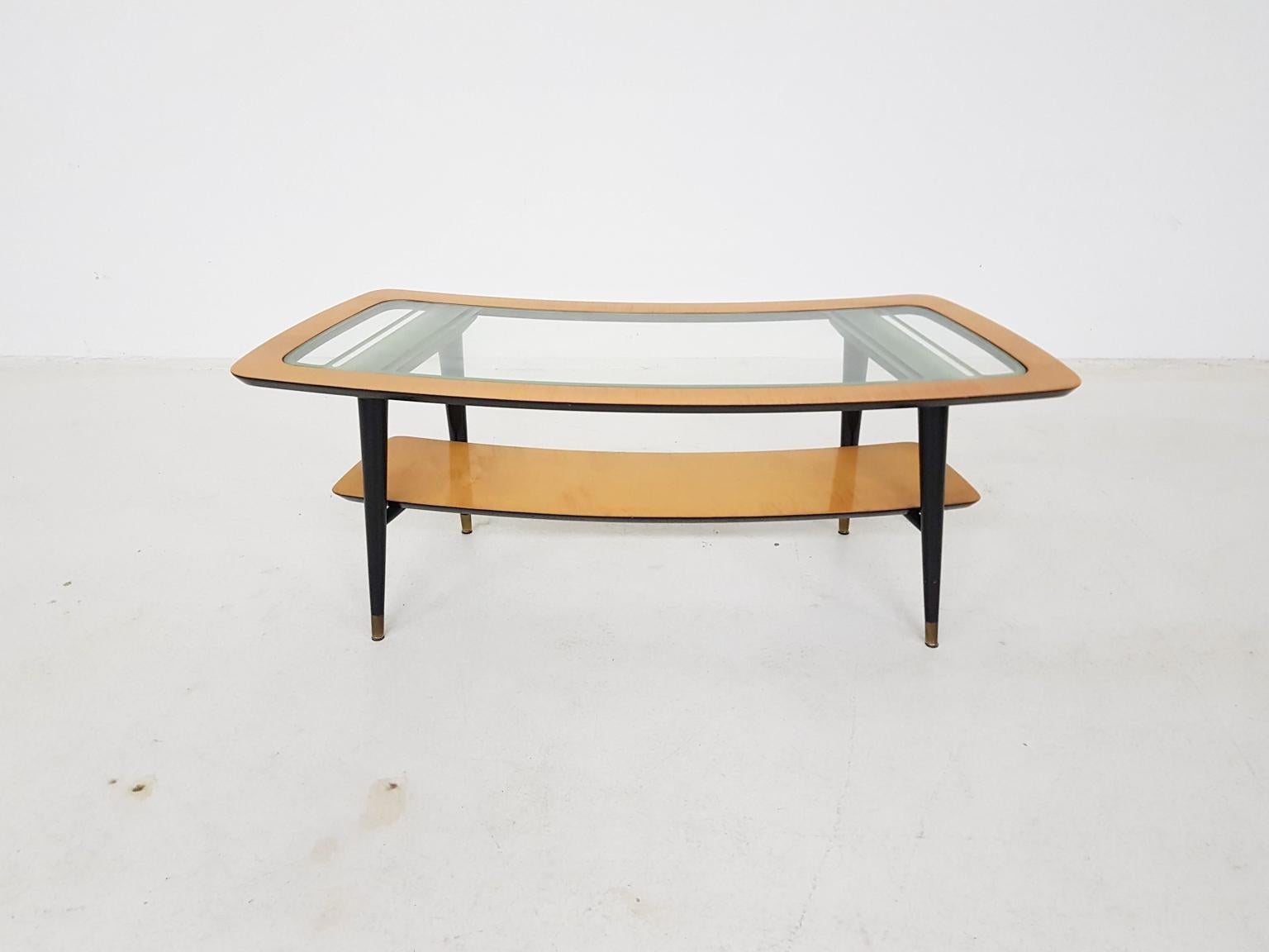 High end boomerang shaped coffee table in birch wood. The legs are black lacquered and have brass feet. It has a glass top with a beautiful sandblasted pattern to hide the construction of the table. It's Italian and in the manner of Gio Ponti and