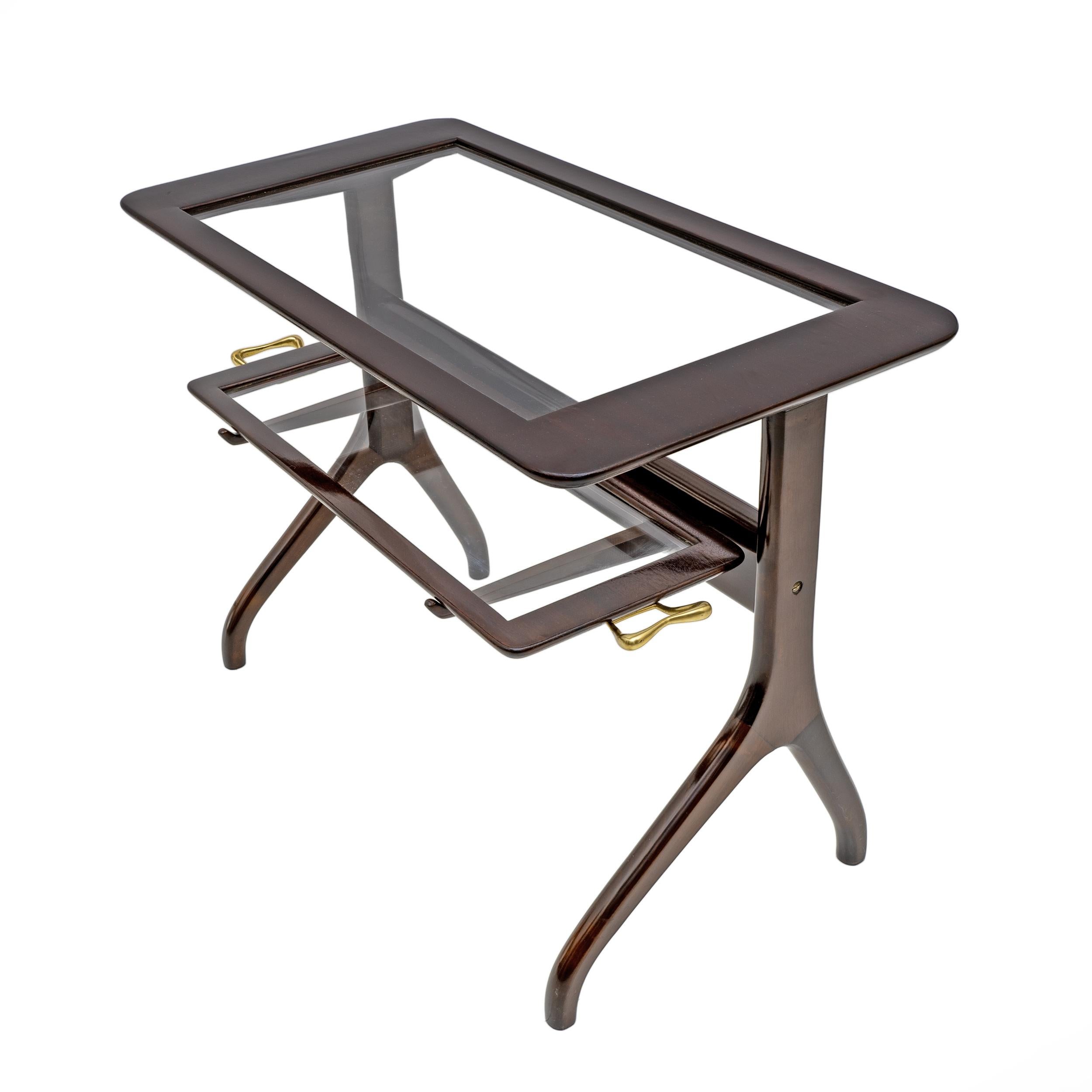 Beautiful coffee table attributed to Ico Parisi, Italy 1950s. This highly refined tray table has a mahogany stained beech base that supports a glass shelf and a removable tray with a wooden frame and brass handles. The elegant sculptural base looks