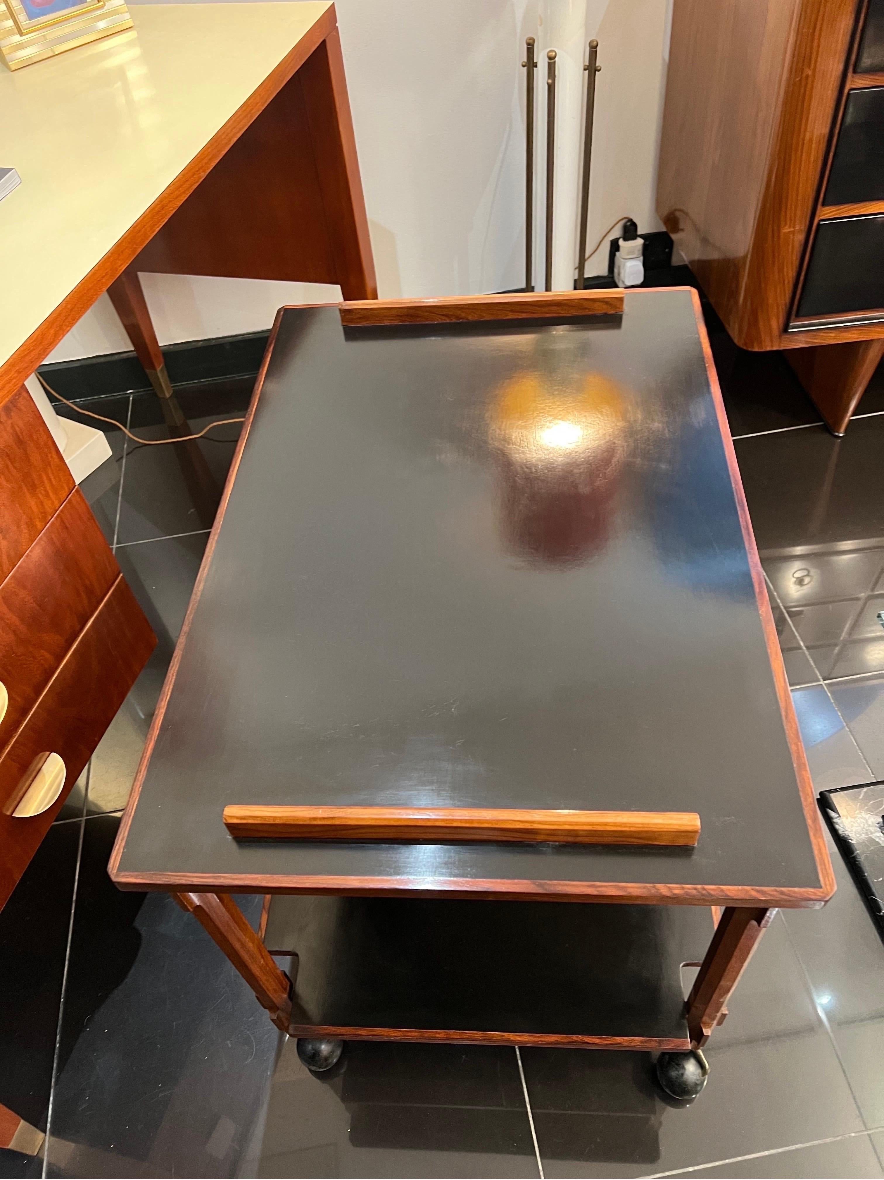 A beautiful architectural two tiered bar cart in solid cherry wood with black lacquered trays by Ico Parisi for Stildomus.

Dimensions: D: 55cm W: 80cm H: 61cm

 