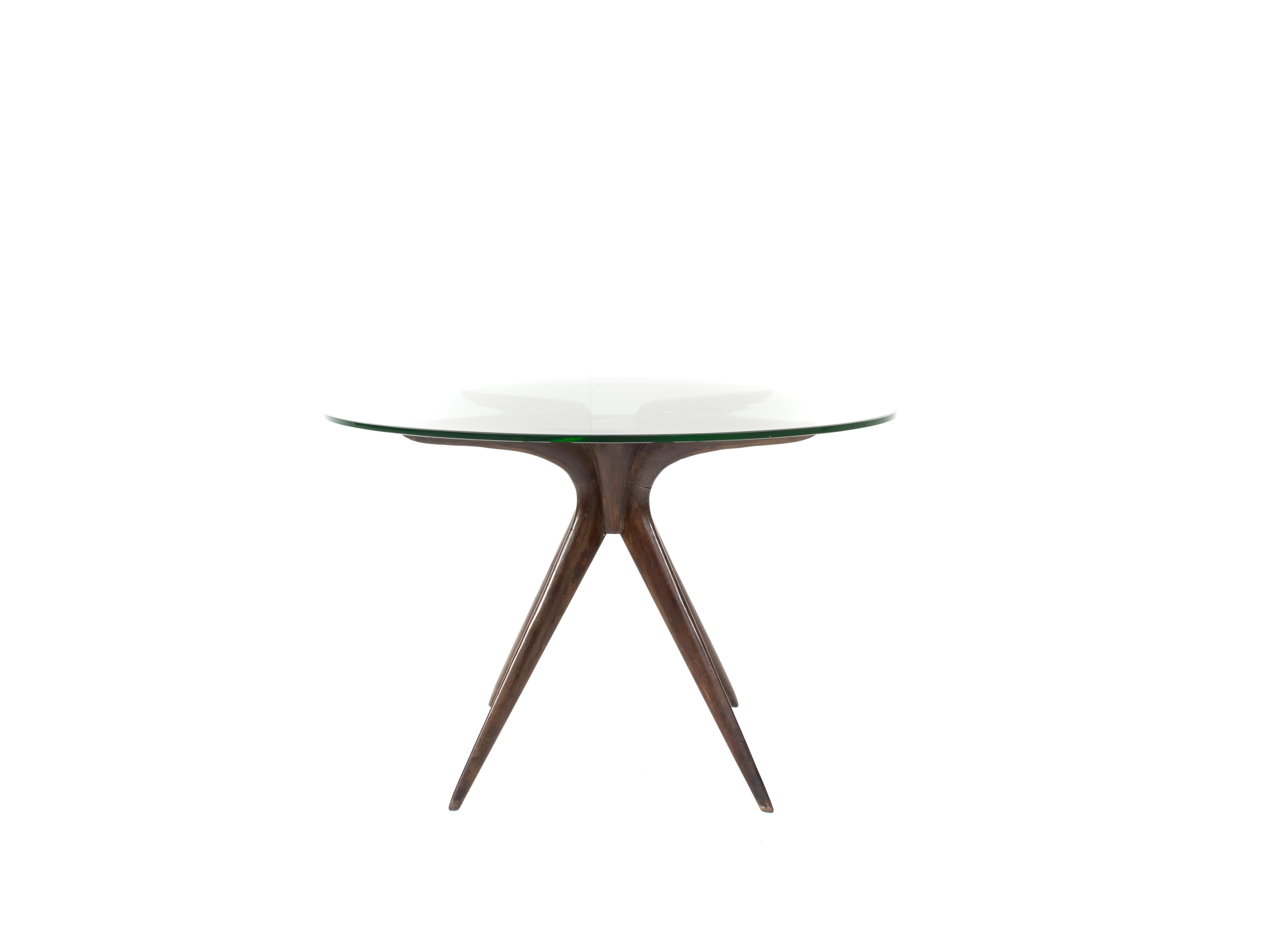 Amazing coffee table in wood and glass attributed to Ico Parisi, Italy, 1950s. This coffee table has a four-legged base. These legs are also used to hold the round glass top. In the middle of the table is a circle to hold the legs together. The