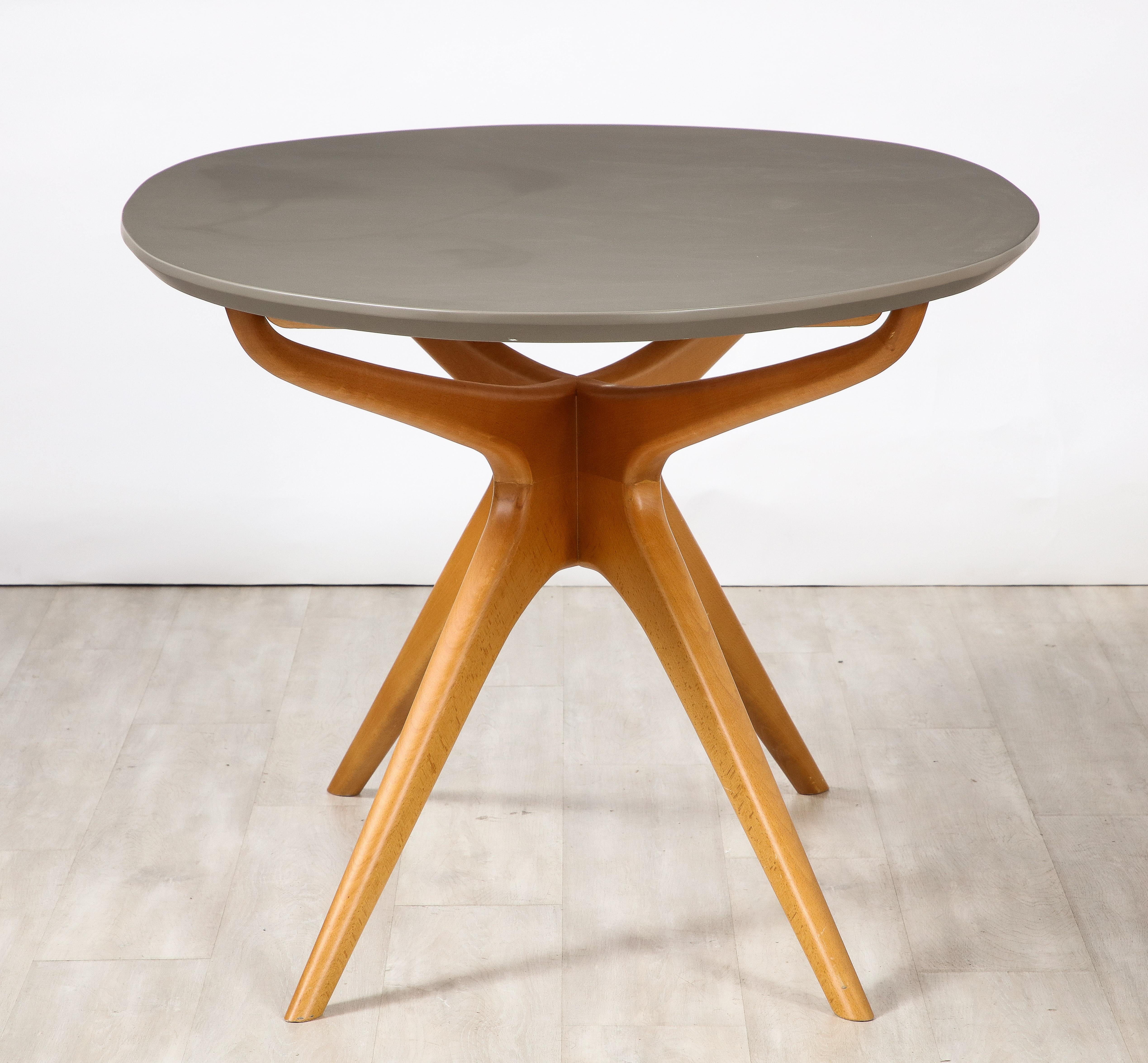 A stunning and highly unusual dining table attributed to visionary Italian designer Ico Parisi, the base in beech wood with dynamic angled legs supporting an oval laminate matte grey top over wood. Together, the whole is a sculptural masterpiece,