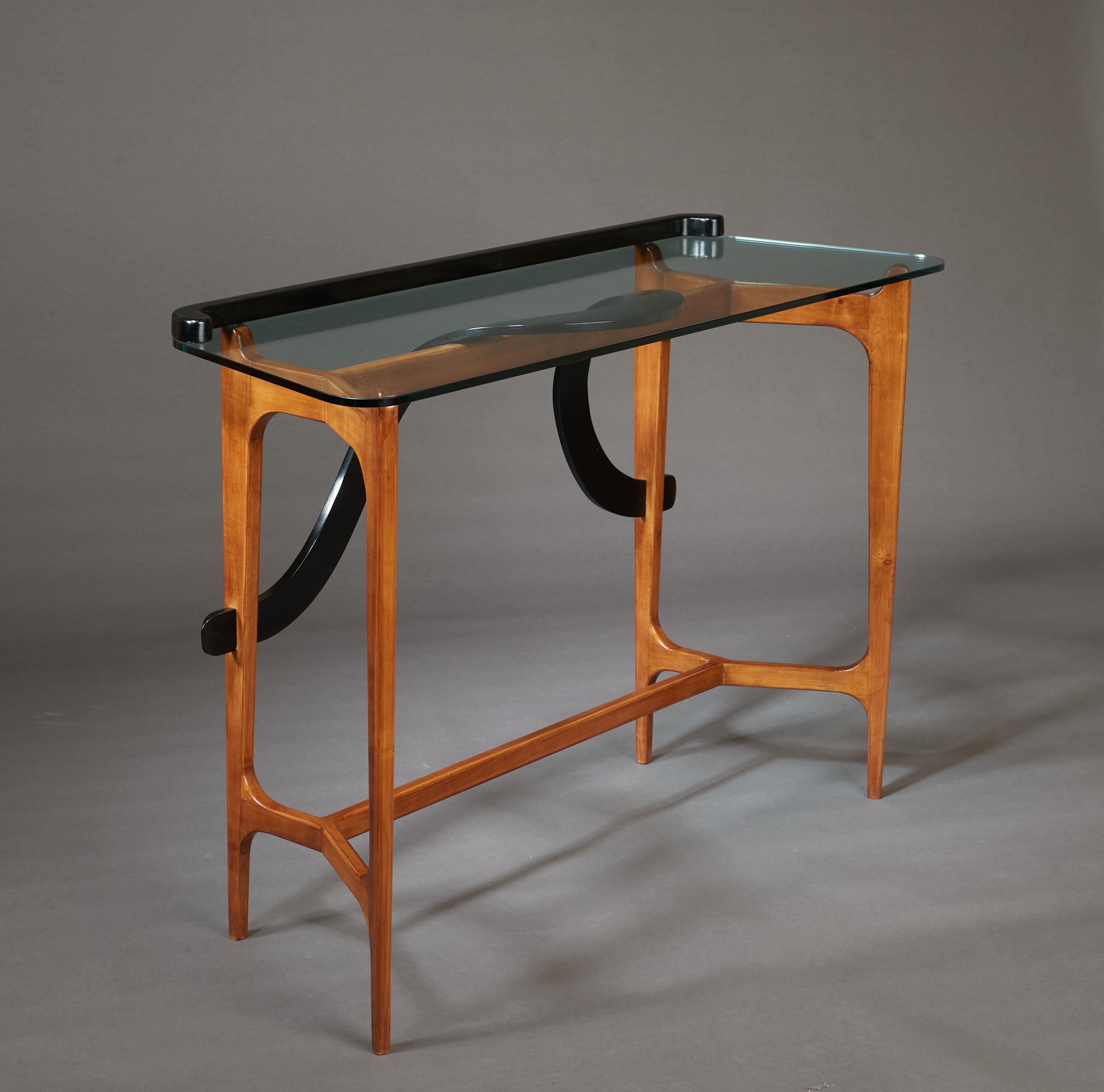 Ico Parisi (1916-1996)

An exceptional sculptural console by Ico Parisi in polished and lacquered walnut. The rounded glass plateau is raised on gracefully modeled and angled legs. A sinuous, starkly three-dimensional carved ribbon, in contrasting