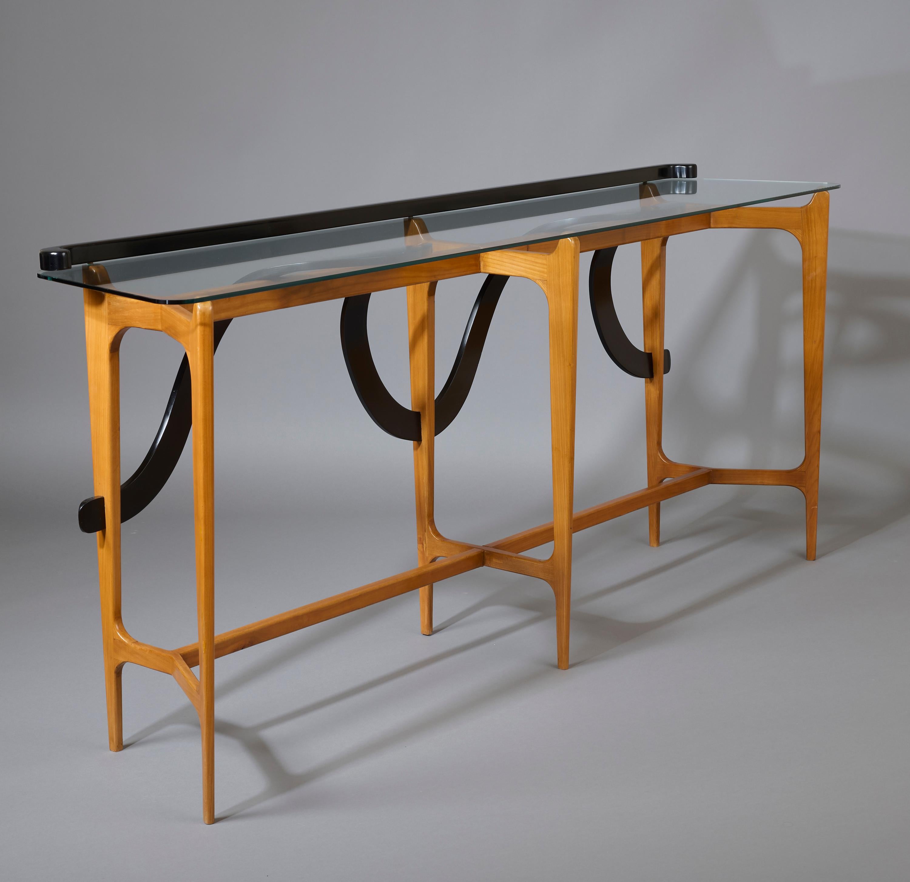 Ico Parisi (1916-1996)

An exceptional sculptural console by Ico Parisi, in polished and lacquered fruitwood. The round-edged glass plateau, topped by a straight lacquered crossbar with jauntily coiled ends, is raised on a trapezoidal base in