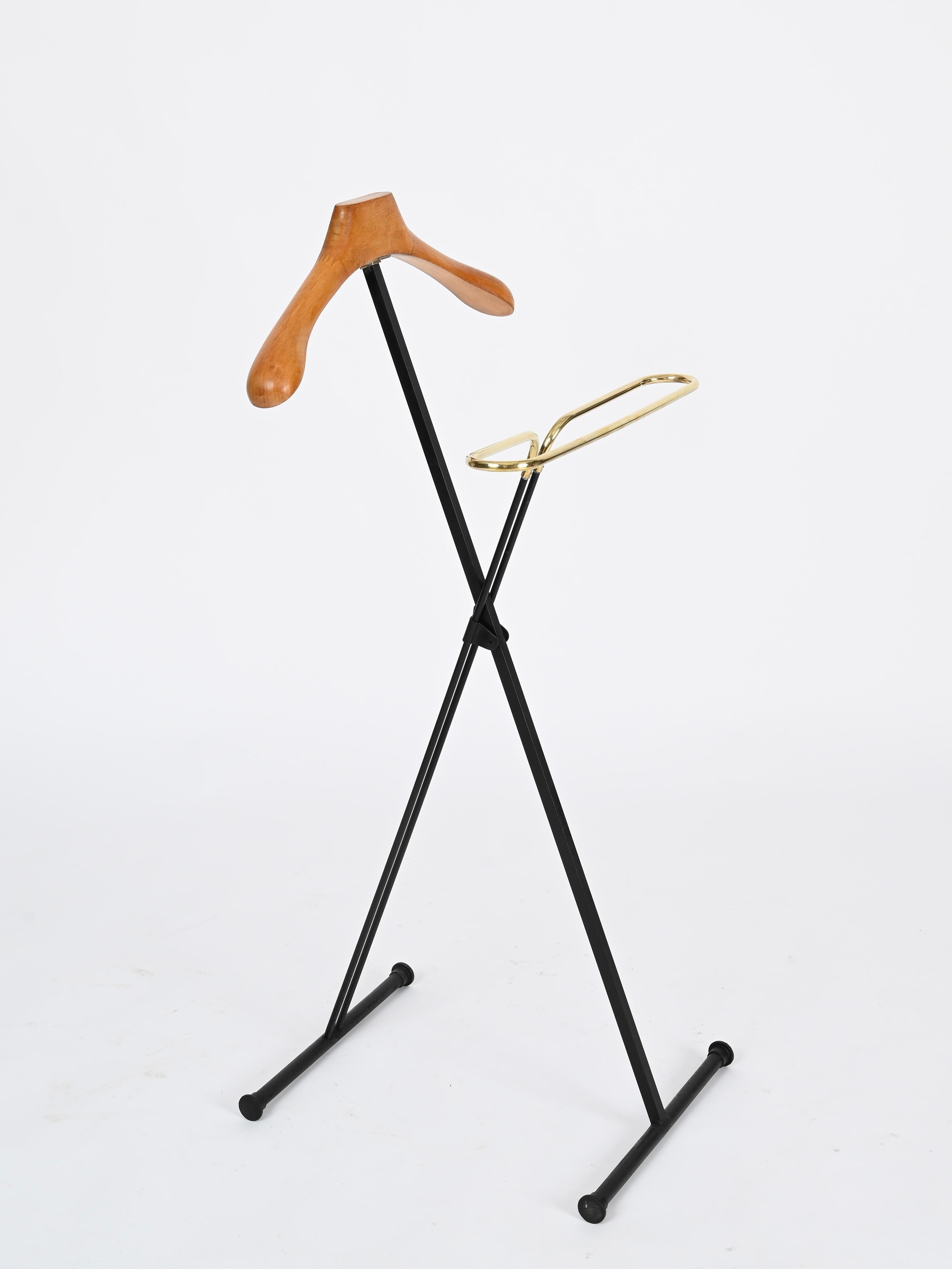Maravilloso e increíblemente raro perchero plegable de mediados de siglo en madera de haya, latón y metal esmaltado en negro. Esta impresionante pieza fue diseñada por Ico Parisi y producida por Fratelli Reguitti en Italia durante la década de 1960.