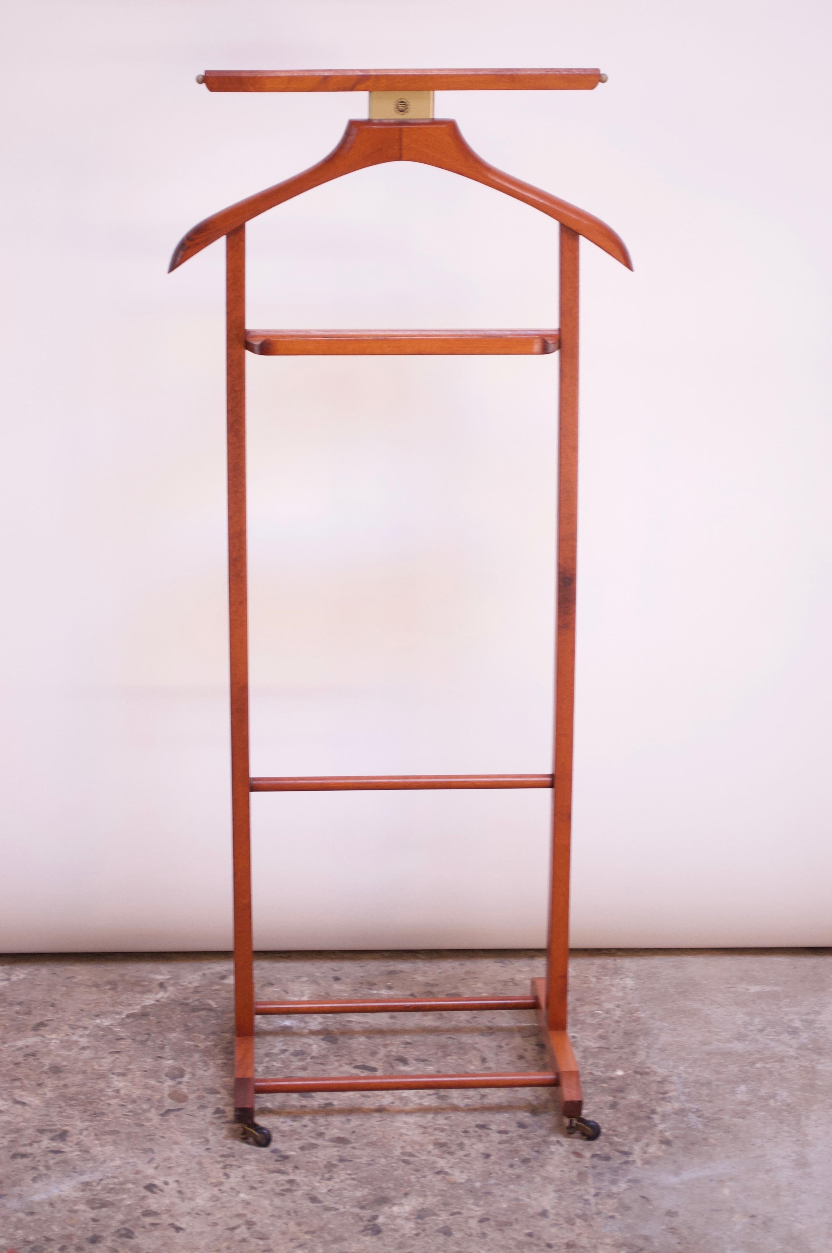 This Italian valet was designed by Fratelli Reguitti in the 1950s. Composed of a frame/hanger and change or cufflink holder with a double rack on the bottom for shoes and four caster wheels for easy mobility. The top bar (intended for hanging