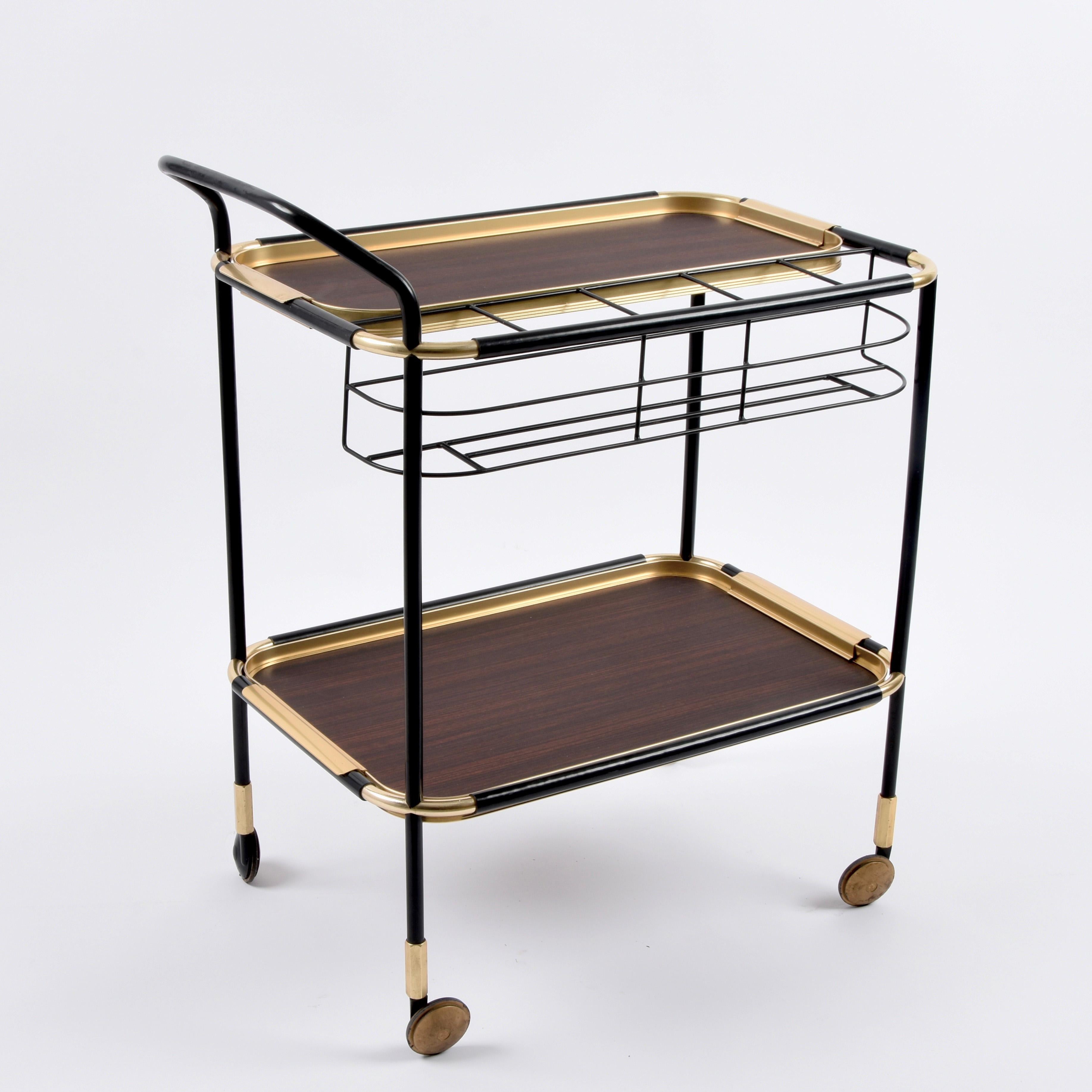 Elegant bottle trolley with two pull-out trays in Khaya Anthotheca Mahogany with mid-century gold aluminium and brass handles. This fantastic piece was designed in Italy by Ico and Luisa Parisi for Mb Italia in the 1960s.

This item surprises for