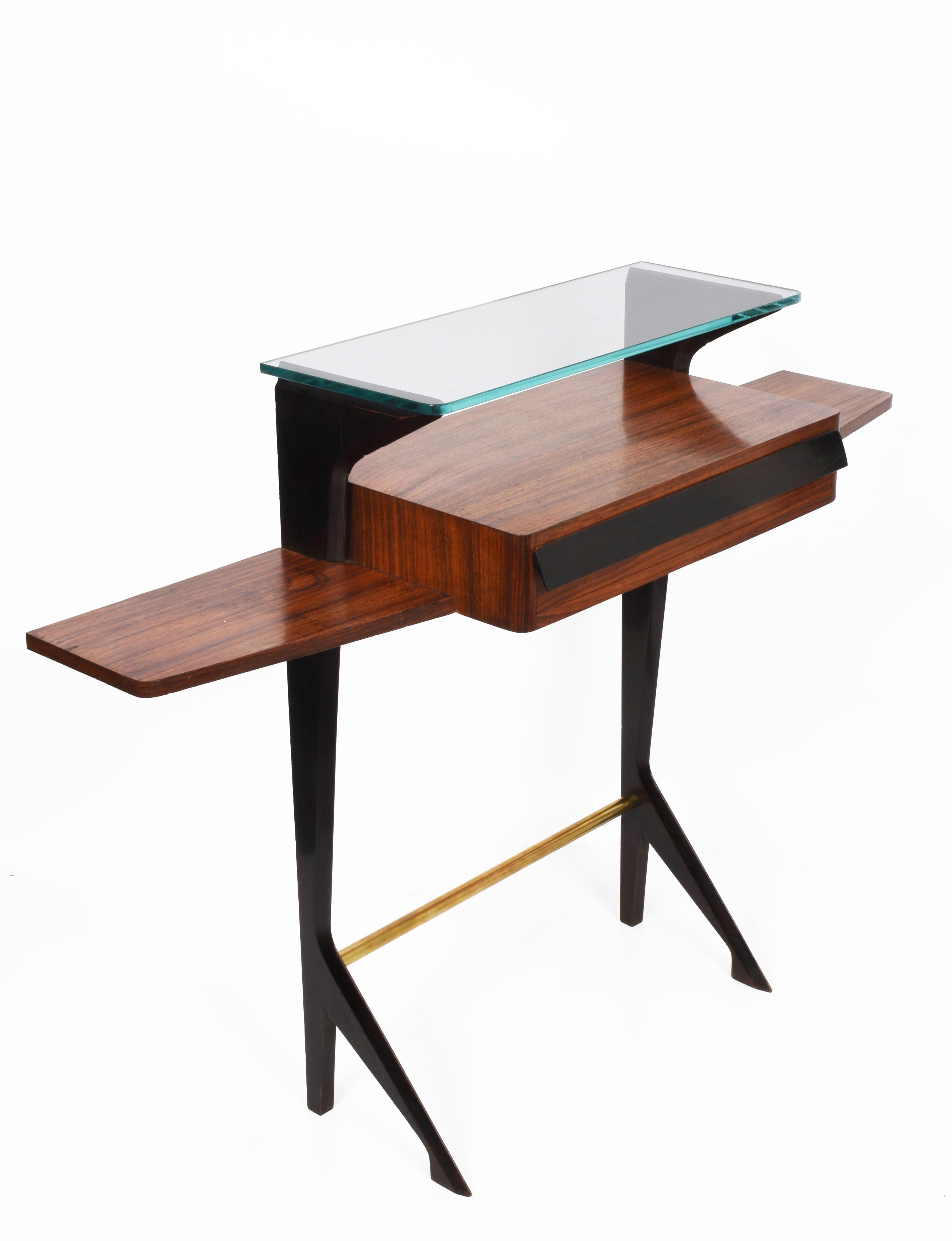 Wonderful midcentury wooden, brass and glass console table attributed to Ico Parisi.

The interior elegance of this surprising piece, the legs in black and the small drawer in black lacquered wood. The legs provide a great open view and show an