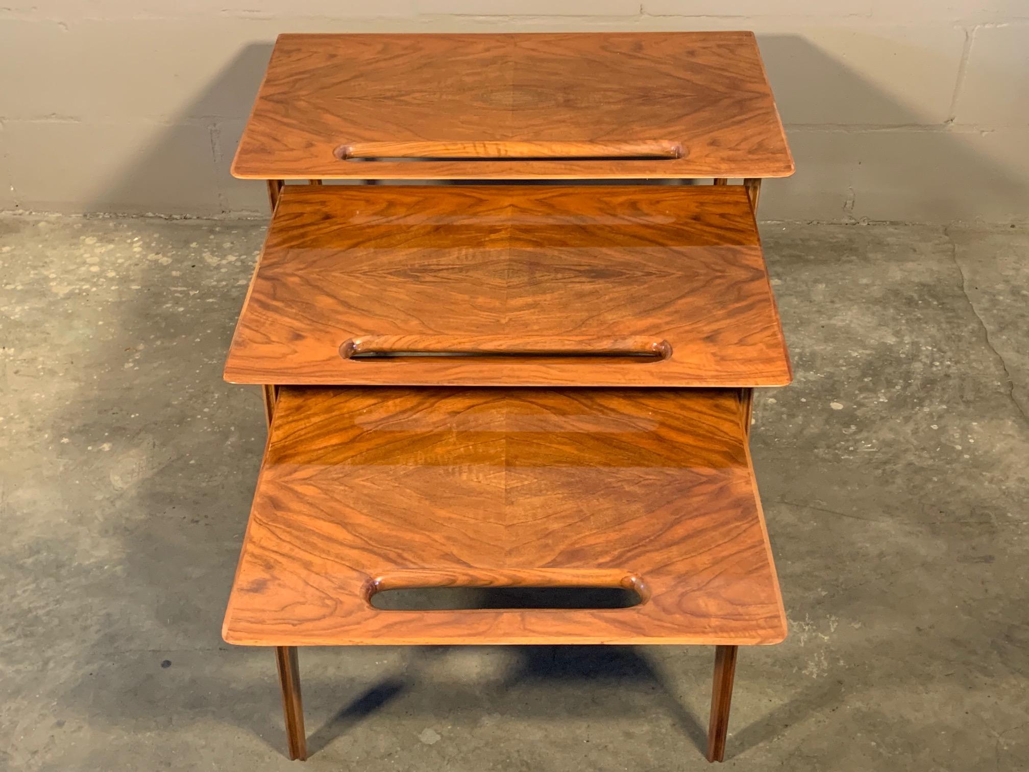 A rare set of three nesting tables with handle cutout and tapering legs. Designed by Ico Parisi and retailed by Singer & Sons. Made of Italian walnut, circa early 1950s.