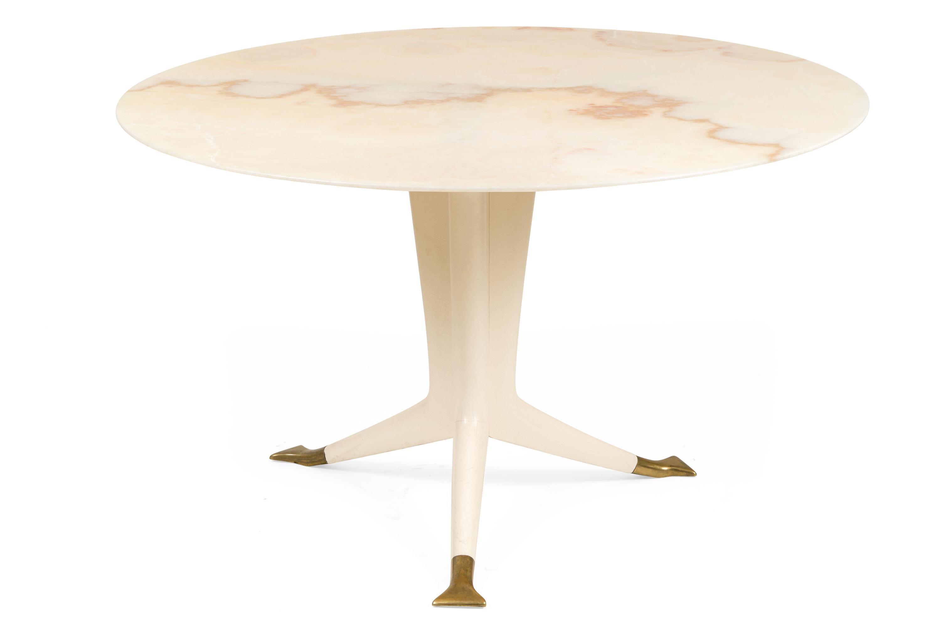A rare and elegant table by Ico Parisi. The structure of the table is composed of a single truncated solid wood element which splits at the base into three long feet finished with flattened brass feet.