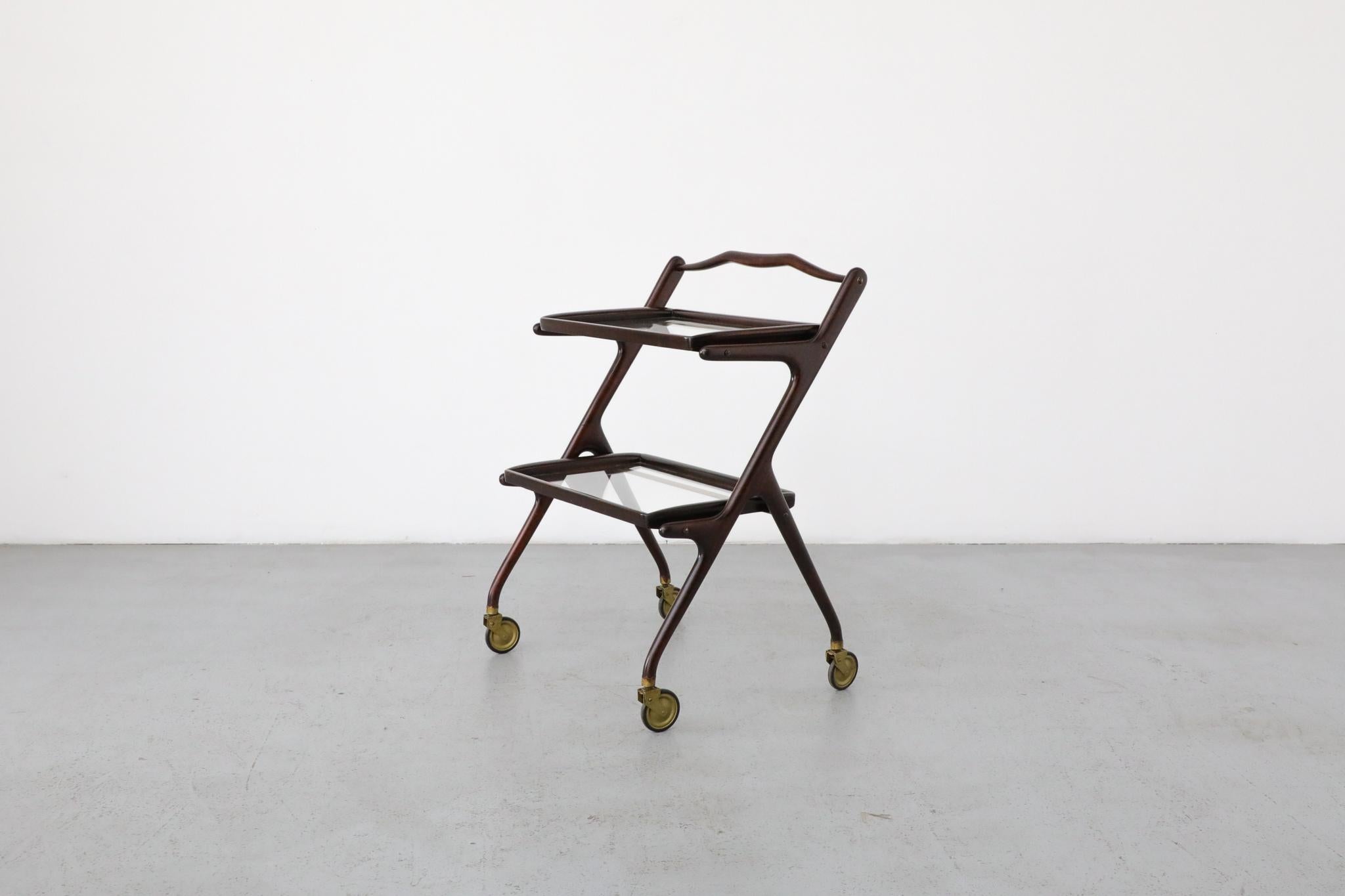 Ico Parisi style dark wood and beautifully patinated brass bar cart or tea trolley with removable dark wood wood and glass trays. Sleek and stylish piece in original condition with wear consistent with age and use. Trays measure: 22.25 x 14.125.