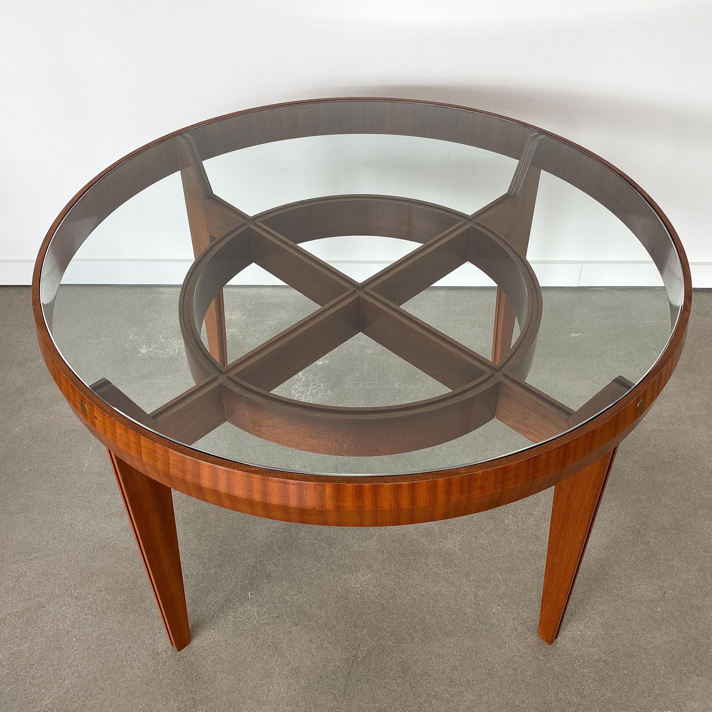 Midcentury Italian walnut center table / dining table in the style of Ico Parisi, circa 1950s. Italian walnut construction with brass circular details at the top of each leg. Inset glass top. 28