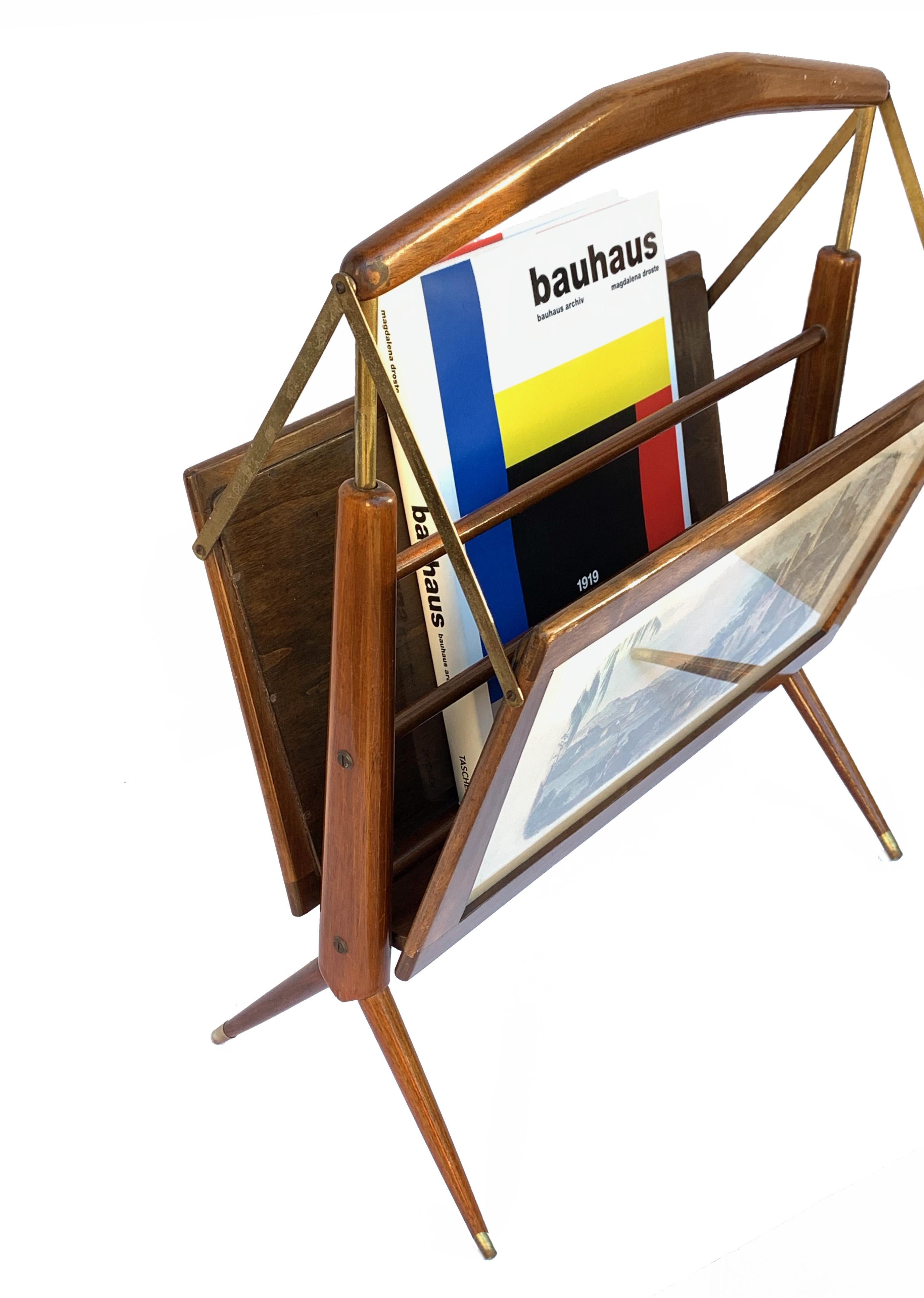 Folding magazine rack from the 1950s in beech and brass details.
It has two watercolor engravings depicting landscapes on each side affixed behind the glass.