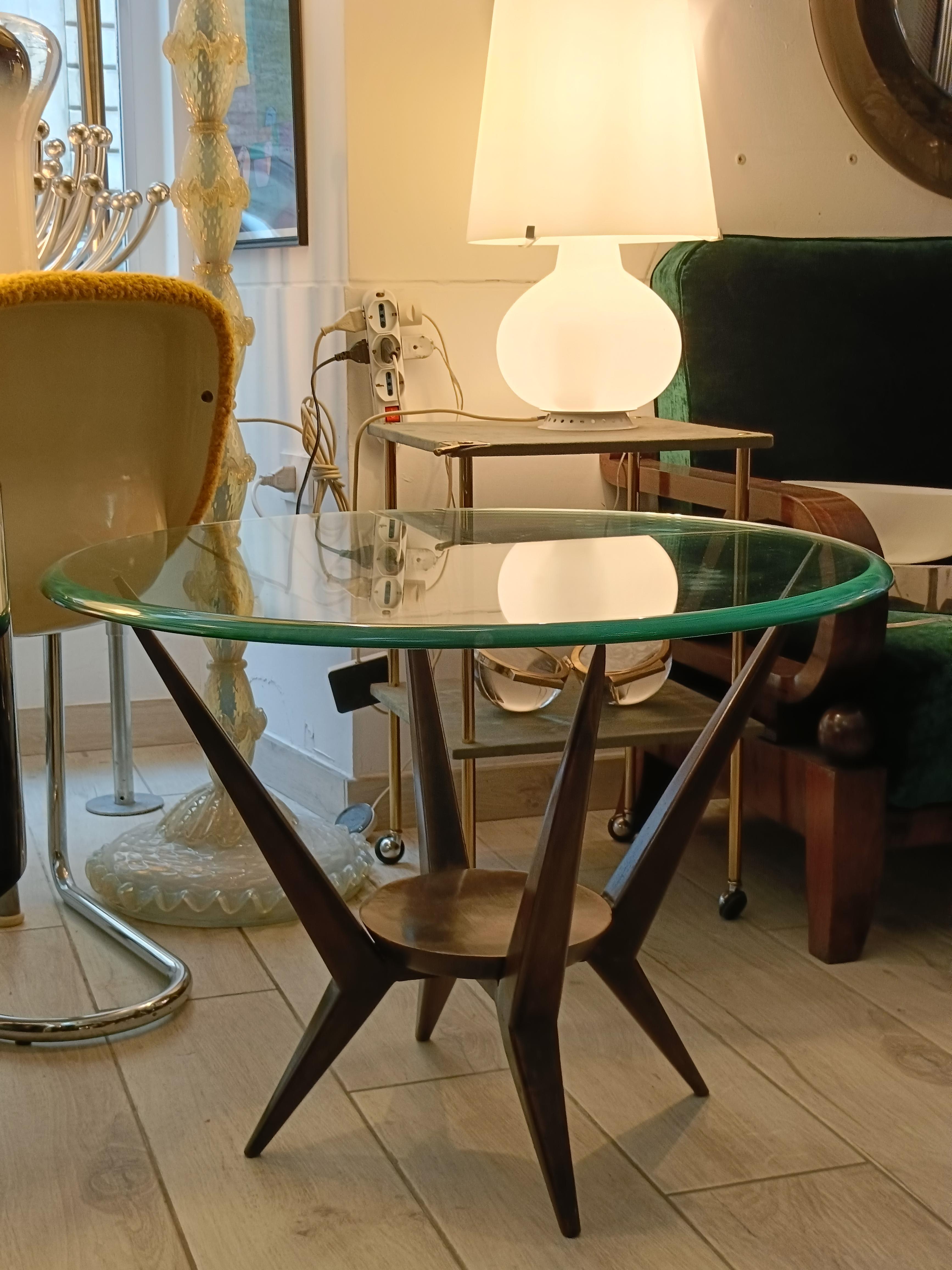Ein sehr markanter Couchtisch aus ebonisiertem Holz und kreisförmiger Glasplatte, der in seiner architektonischen Eleganz an die berühmten strukturellen Entwürfe von Ico Parisi und Vittorio Dassi erinnert,
Ästhetisch ist das Tischgestell ein wahres