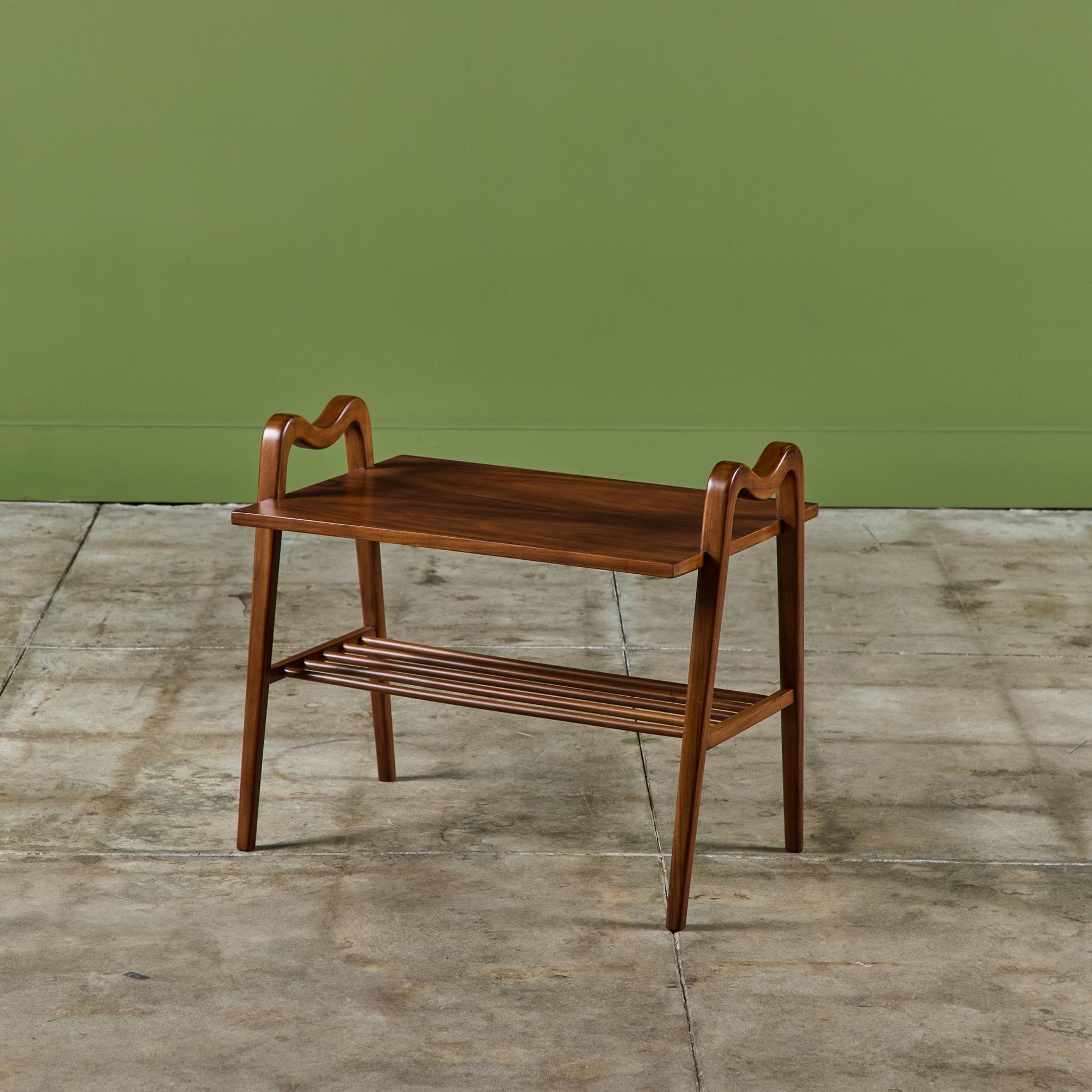 Table d'appoint à deux niveaux dans le style d'Ico Parisi. La table en noyer est dotée d'une étagère inférieure en fuseau et d'un plateau rectangulaire. La table est flanquée de poignées incurvées qui descendent le long de la table jusqu'à chacun