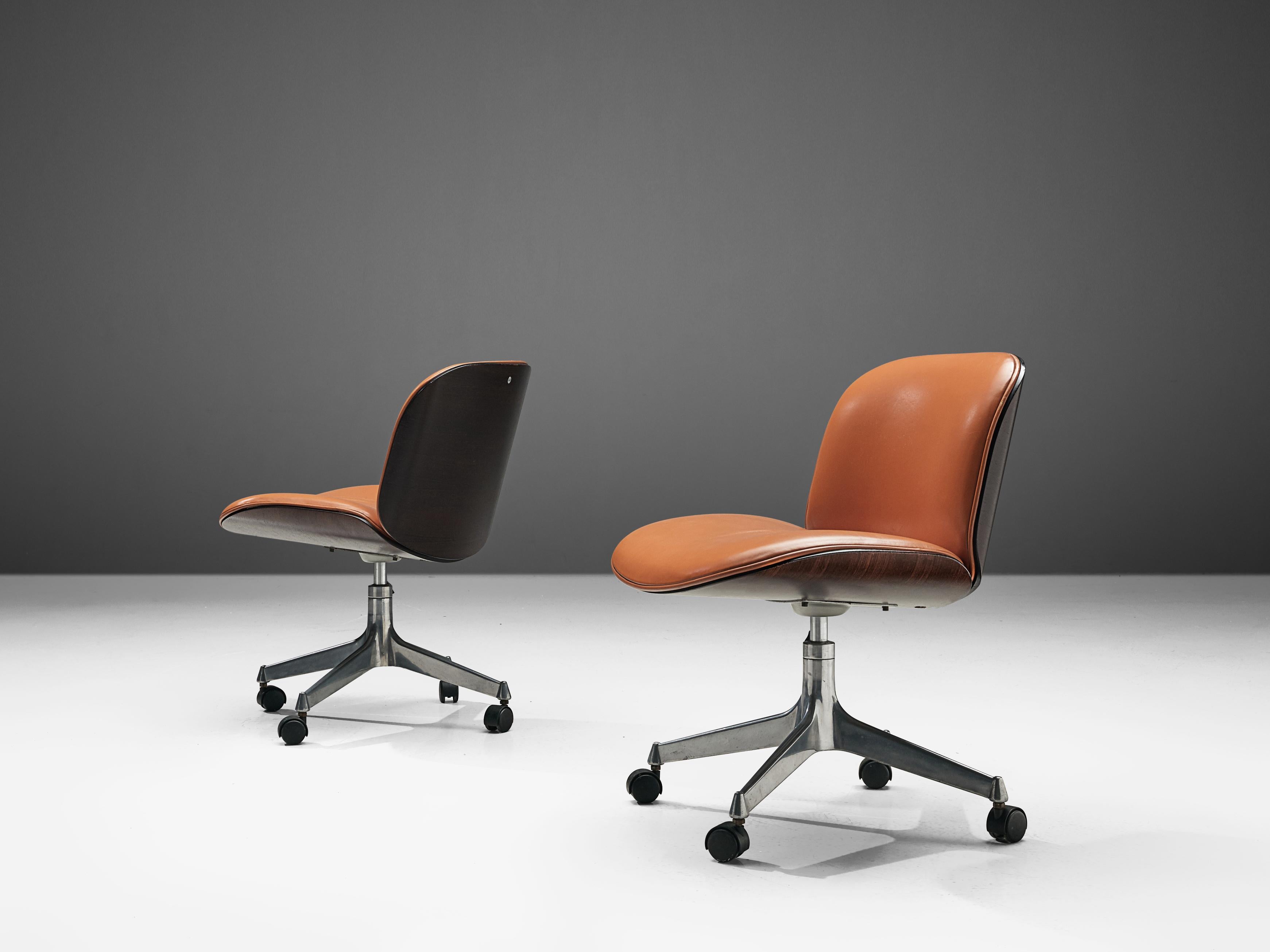 Ico Parisi for MIM Roma, office chairs, rosewood, metal and leatherette, Italy, 1960s.

Swivel chairs from the 'Terni' series by MIM Roma. The seating and back consist of curved rosewood shells which hold the orange leatherette cushions. Both