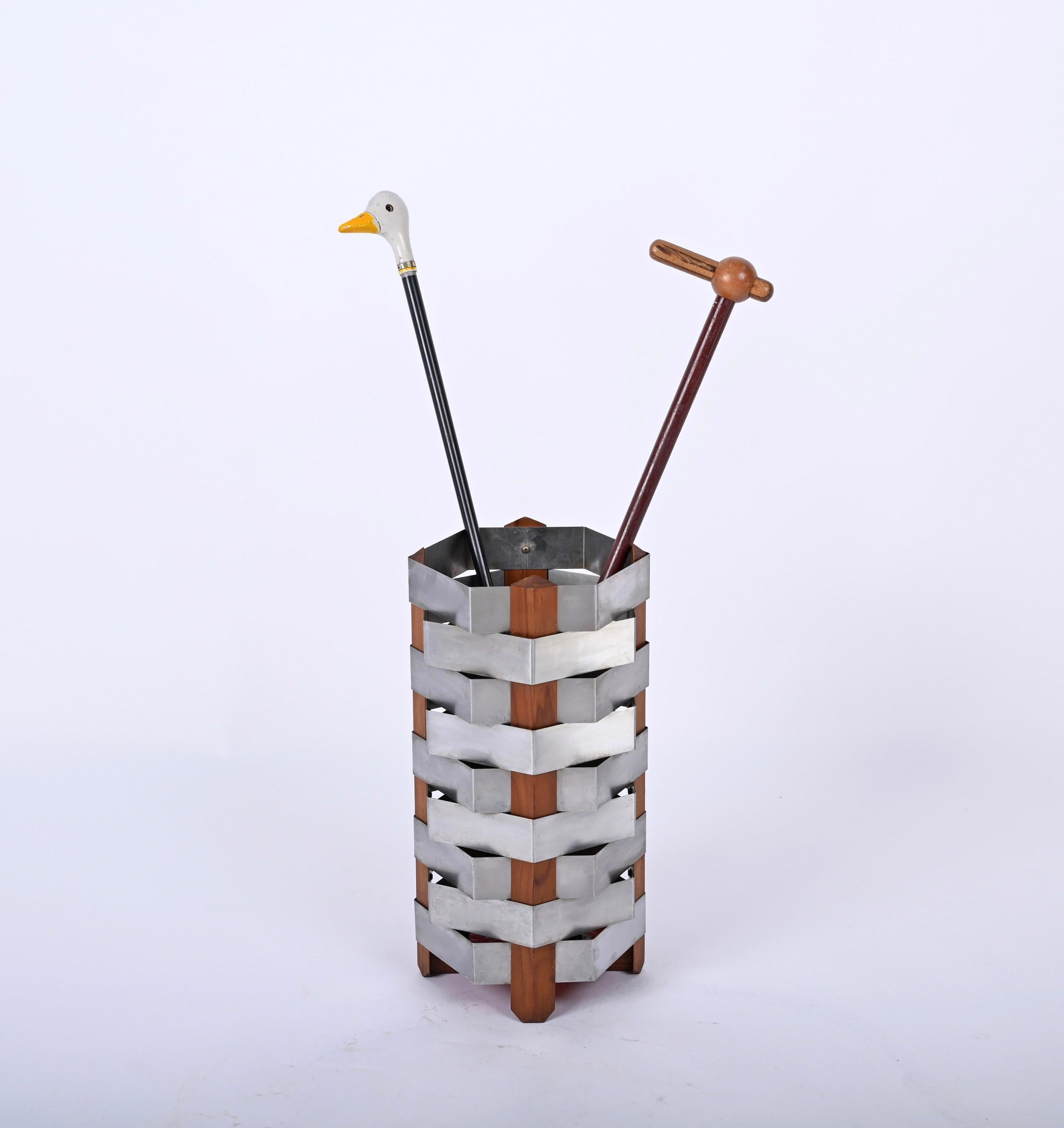 Perseo umbrella stand, model 1701 designed by Ico Parisi and produced by Stildomus in Italy in 1959. 

This incredible piece is made of four triangular supports in solid teak wood that hold together an elegant weave of stainless steel strips