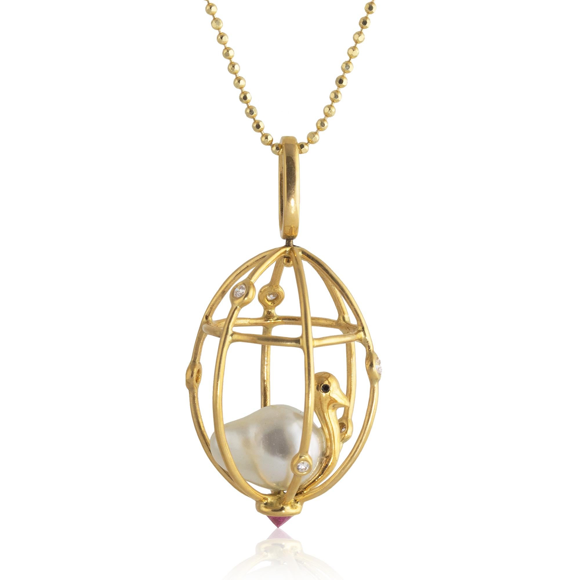 Perched inside this 18k diamond studded cage is a delicate bird; its body made from a 12mm x 9mm Baroque pearl, black diamond eyes decorating its golden body. The pendant features a reverse set .30 carat ruby at the bottom of the cage and swirls in