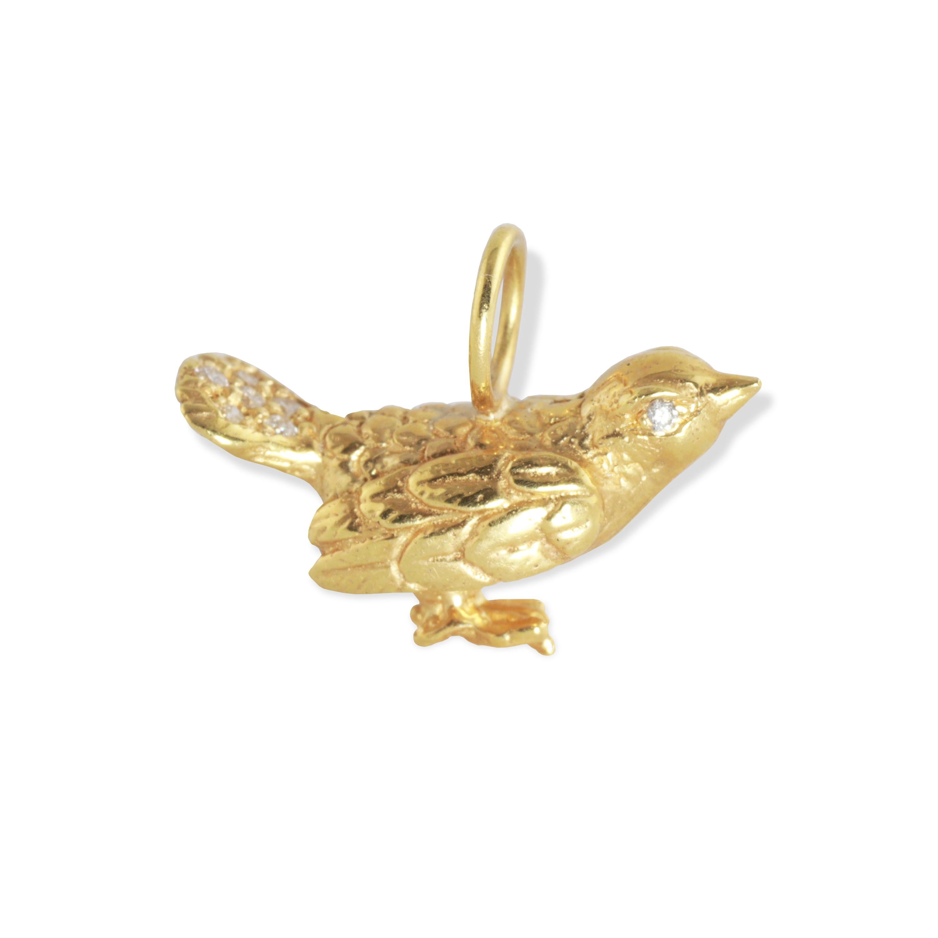 A delicate Bird pendant with .04 carats of diamonds decorating the tail and eyes in 18k yellow gold.
The pendant has tiny feet in which the bird can stand on its own.   The pendant symbolizes peace and transformation and was made in collaboration