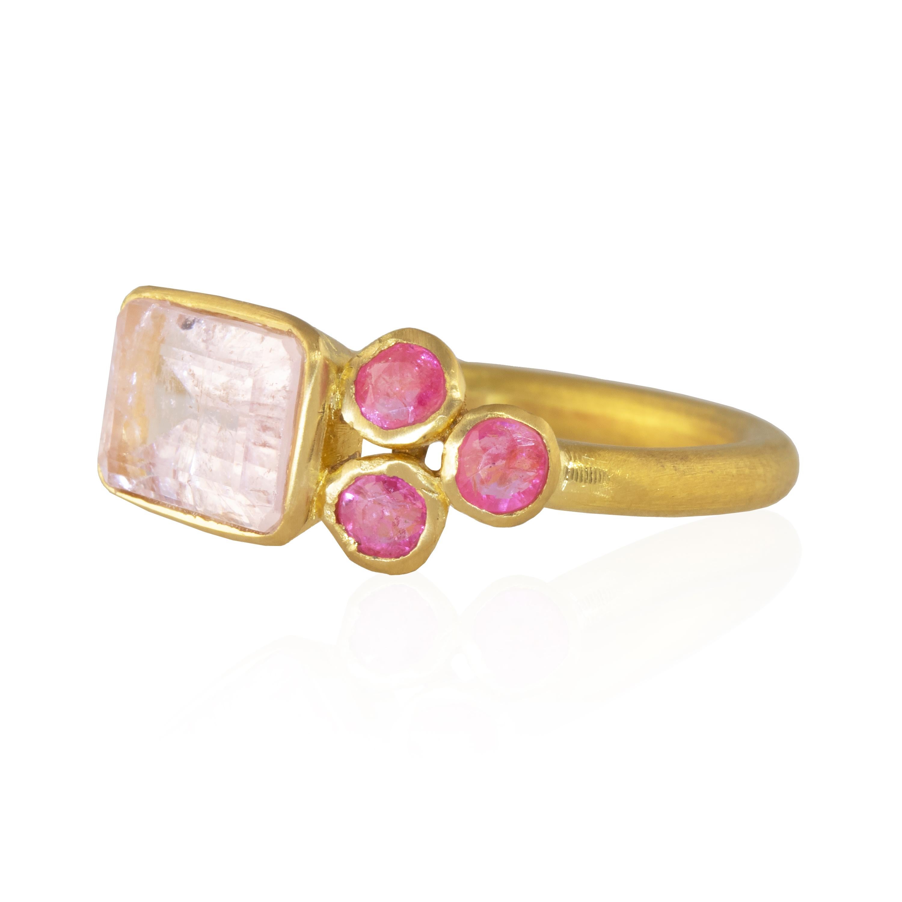 This gorgeous ring features an emerald cut morganite in the center with three hot pink spinels on both sides. Hand made with artisans in Jaipur, this is one of a kind and set in 22k yellow gold. 

Morganite, with its lovely pink hue, is associated