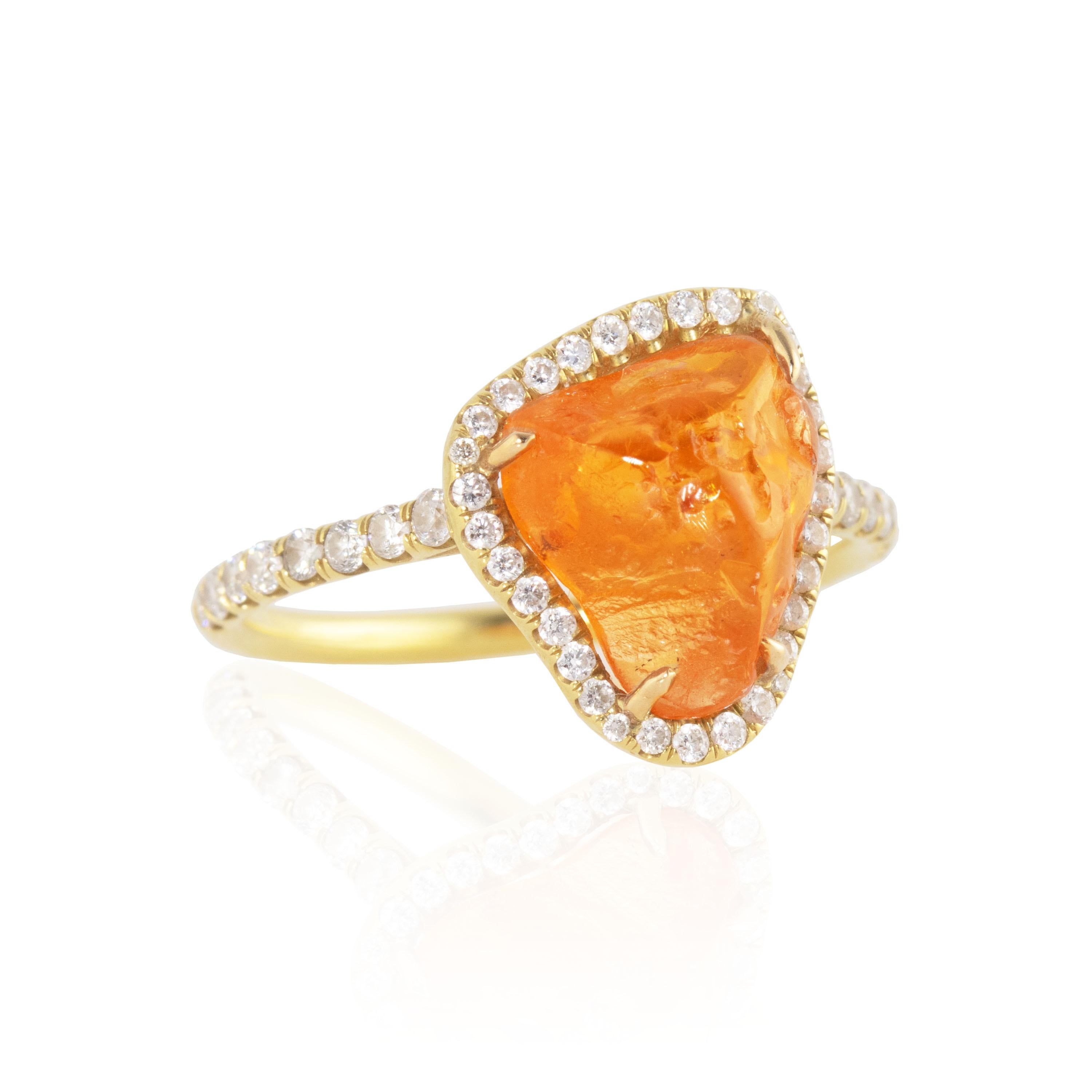 Featuring a large orange, rough cut Fanta Orange Spessartite Garnet center stone and surrounded by diamonds, this ring was inspired by the reflections of the sun on ocean waves.  Featuring a 9.96 carat bright orange rough Spessartite Garnet