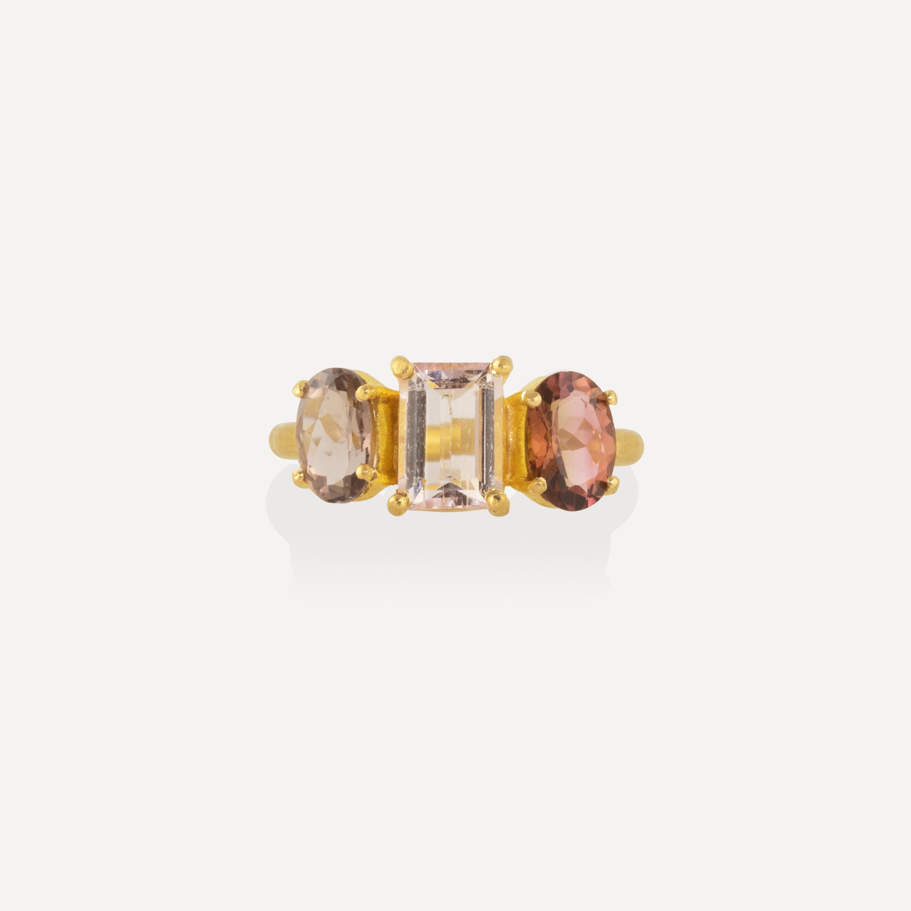 Ein zeitloser Ring mit 3,75 Karat mehrfarbigen Turmalinen. In der Mitte befindet sich ein hellrosafarbener Edelstein im Smaragdschliff, mit tieferen, komplementärfarbigen Ovalen an den Seiten. Die Edelsteine sind in 22-karätigem Gold gefasst und