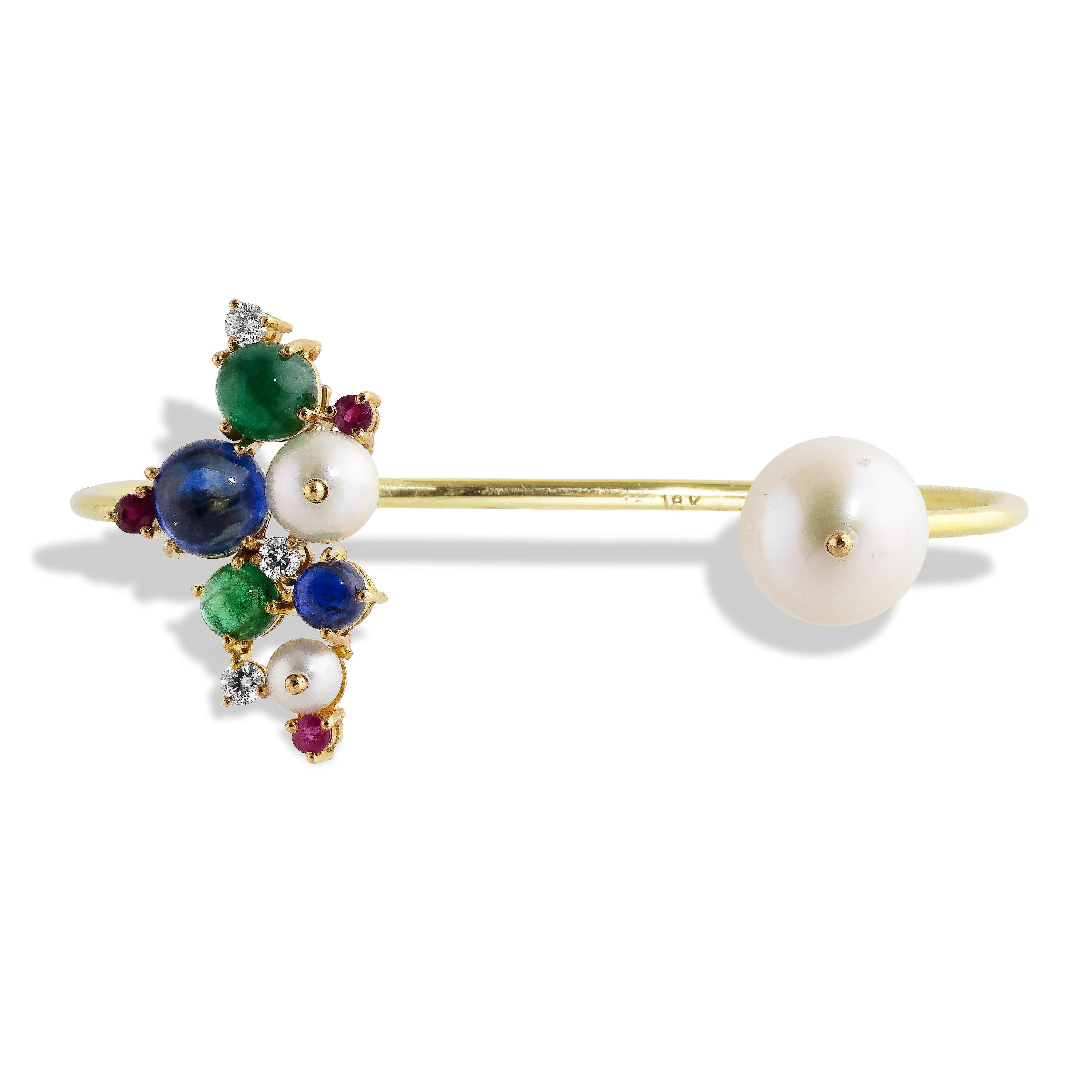 A cluster of Tanzanite, Emerald cabochons with Rubies, Diamonds and Pearls form a cluster open cuff bracelet set in 18k yellow gold.  One side features an 11mm Fresh Water Pearl, the cluster features an 8mm and 5mm Tanzanite Cabochon, 6.5mm and 5mm