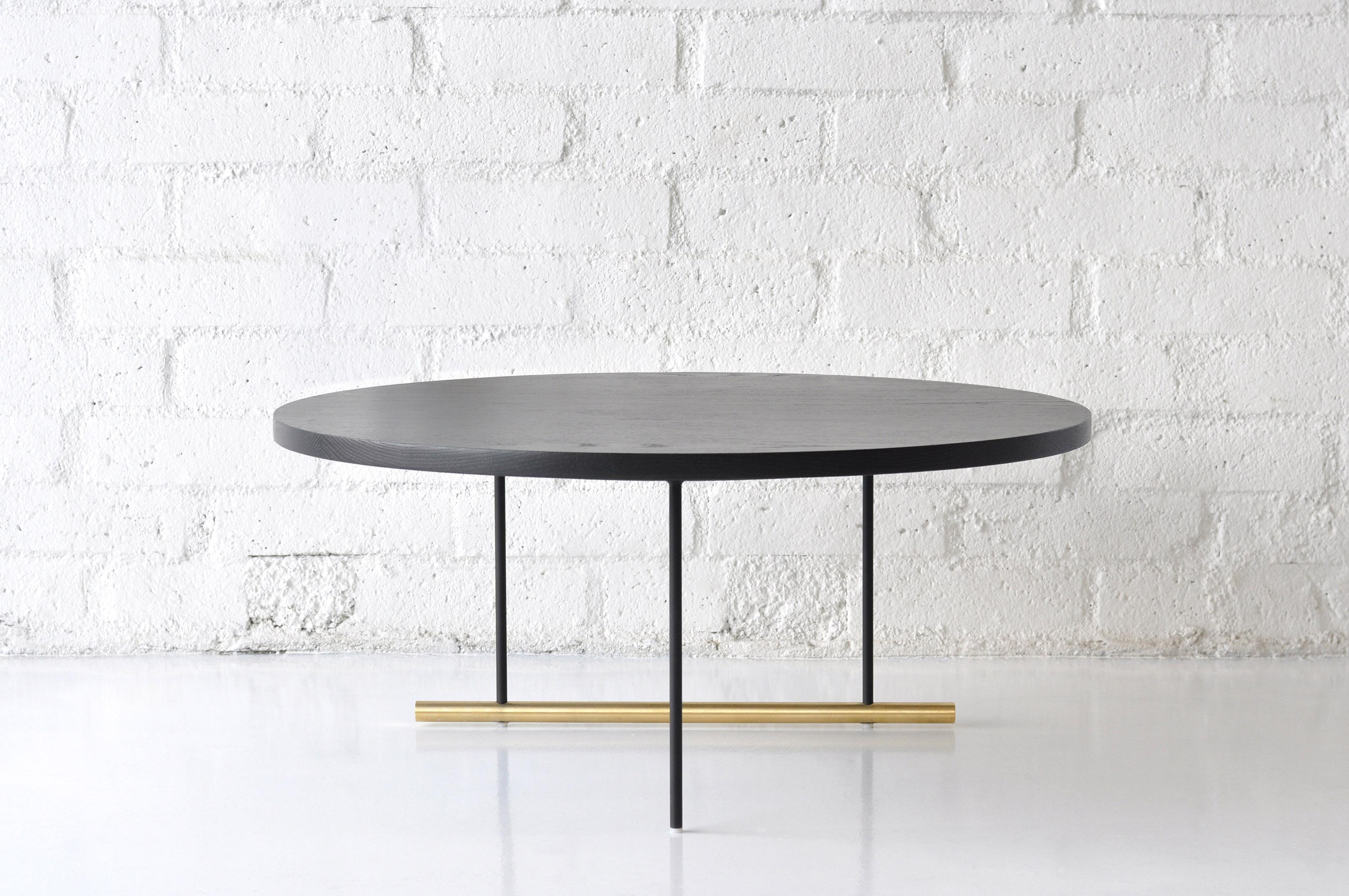Icon Large Ebonized Oak Coffee Table by Phase Design
Dimensions: Ø 88.9 x H 38.1 cm. 
Materials: Ebonized oak, powder-coated metal and brushed brass.

Solid steel and brass with glass, marble, or solid wooden tops. Steel bar available in a flat