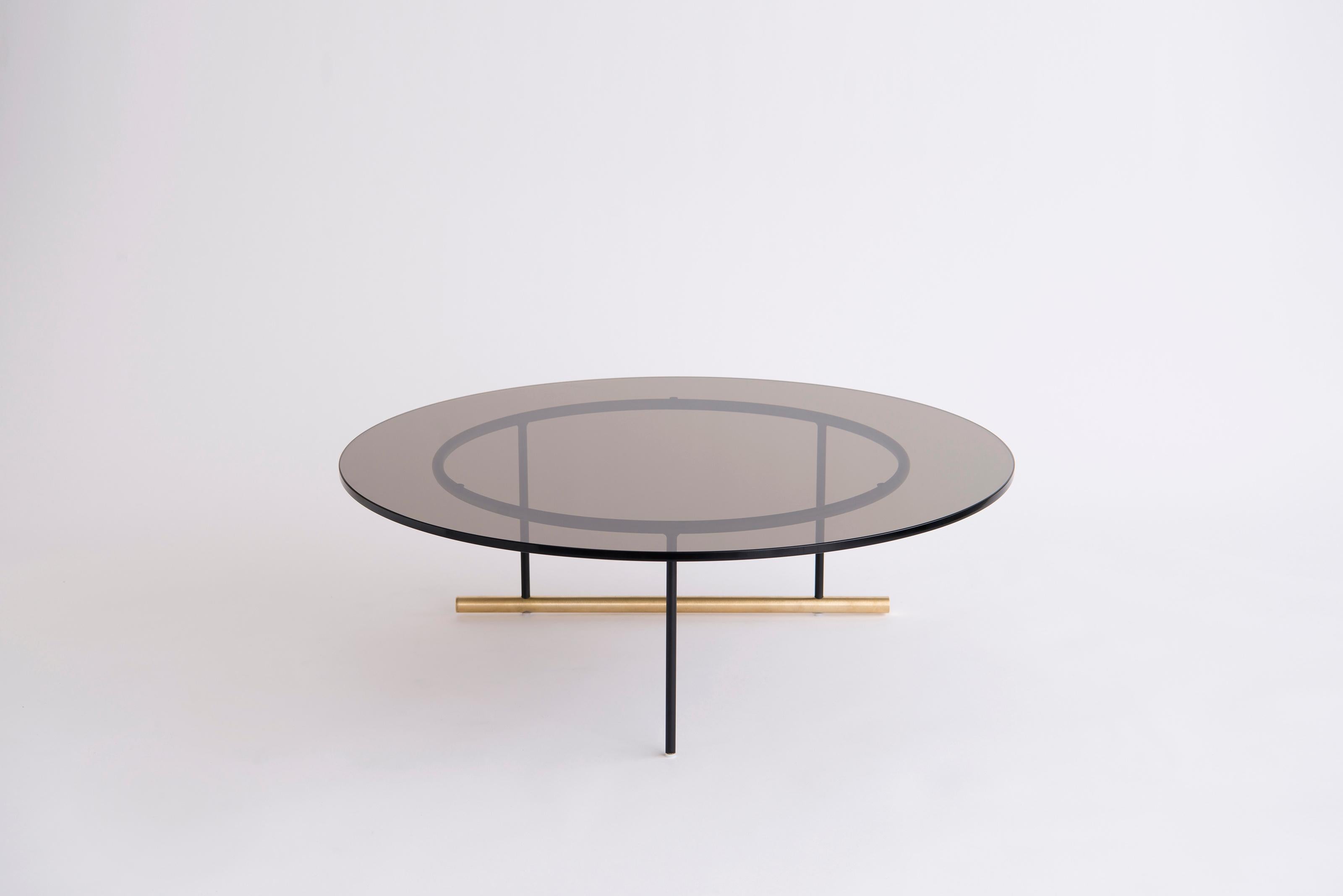 Icon Large Glass Coffee Table by Phase Design
Dimensions: Ø 88.9 x H 38.1 cm. 
Materials: Glass, powder-coated metal and brushed brass.

Solid steel and brass with glass, marble, or solid wooden tops. Steel bar available in a flat black or white