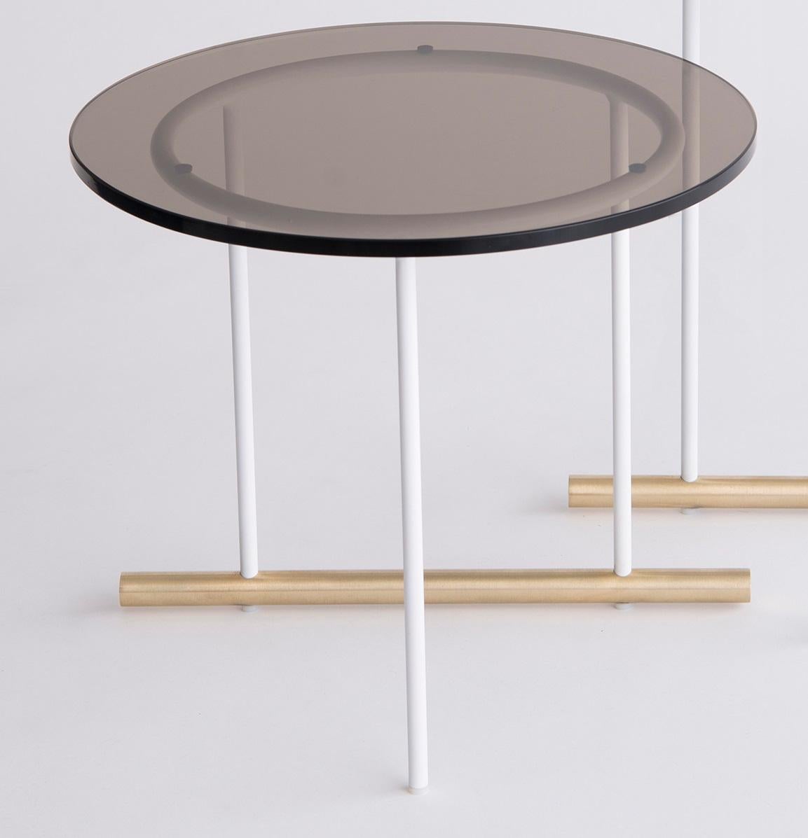 Icon Medium Glass Coffee Table by Phase Design
Dimensions: Ø 45.7 x H 40.6 cm. 
Materials: Glass, powder-coated metal and brushed brass.

Solid steel and brass with glass, marble, or solid wooden tops. Steel bar available in a flat black or white