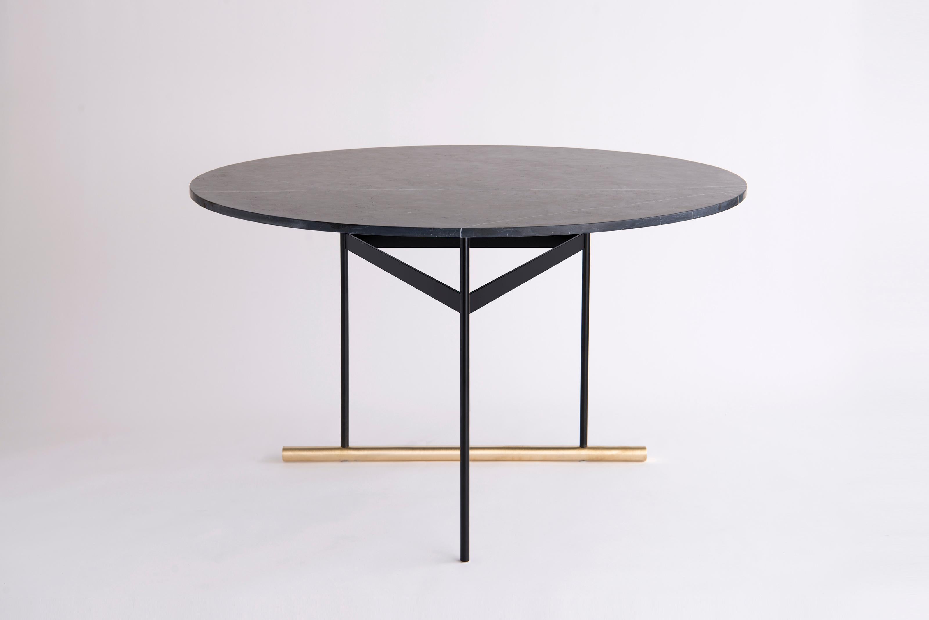 Icon Negro Marquina Dining Table by Phase Design
Dimensions: Ø 122 x H 74.3 cm. 
Materials: Negro Marquina marble, powder-coated metal and brushed brass.

Solid steel and brass with glass, marble, or solid wooden tops. Steel bar available in a flat